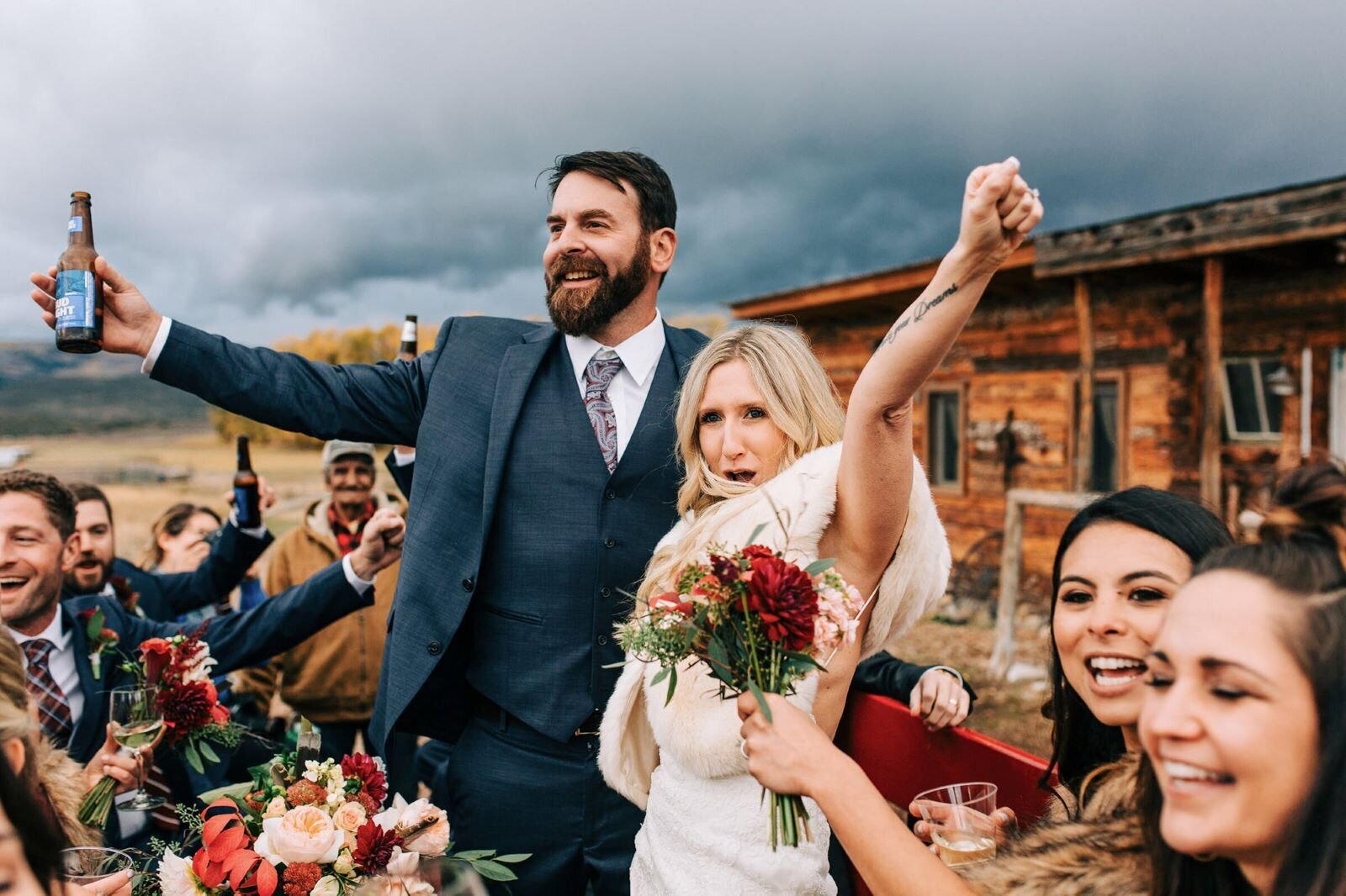Candid photo of couple cheering with their wedding party in Vail