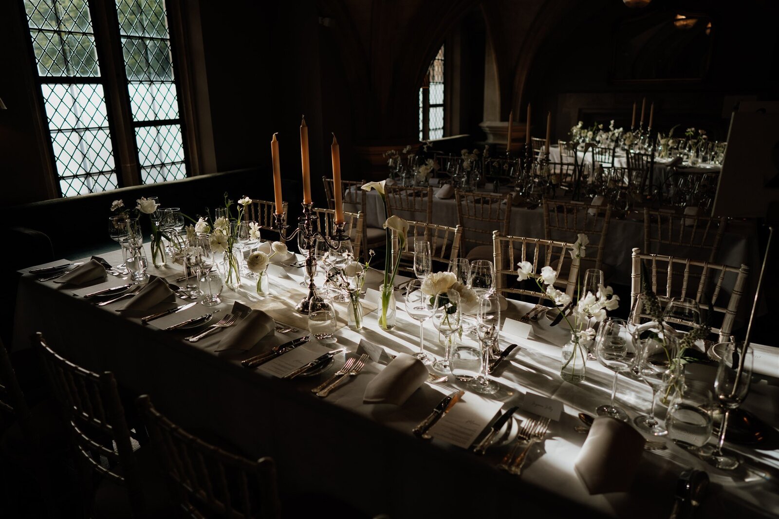 cinematic photography at lincolns inn member common room set up for reception with white flowers and modern tables