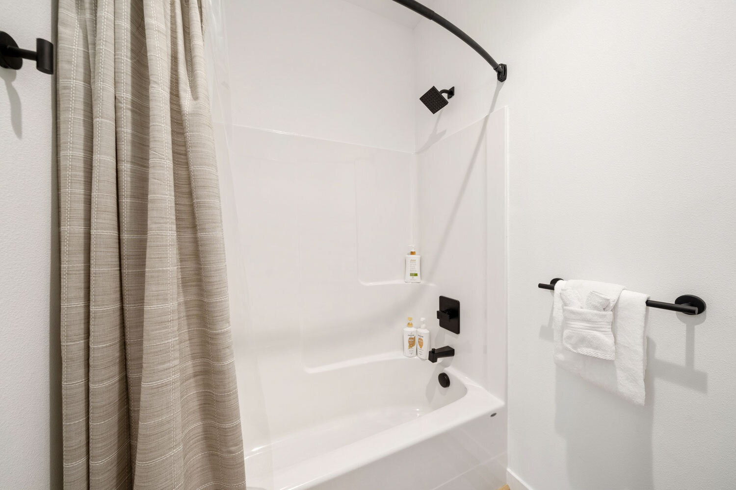 Modern white bathtub with towel, overlooking a forest view
