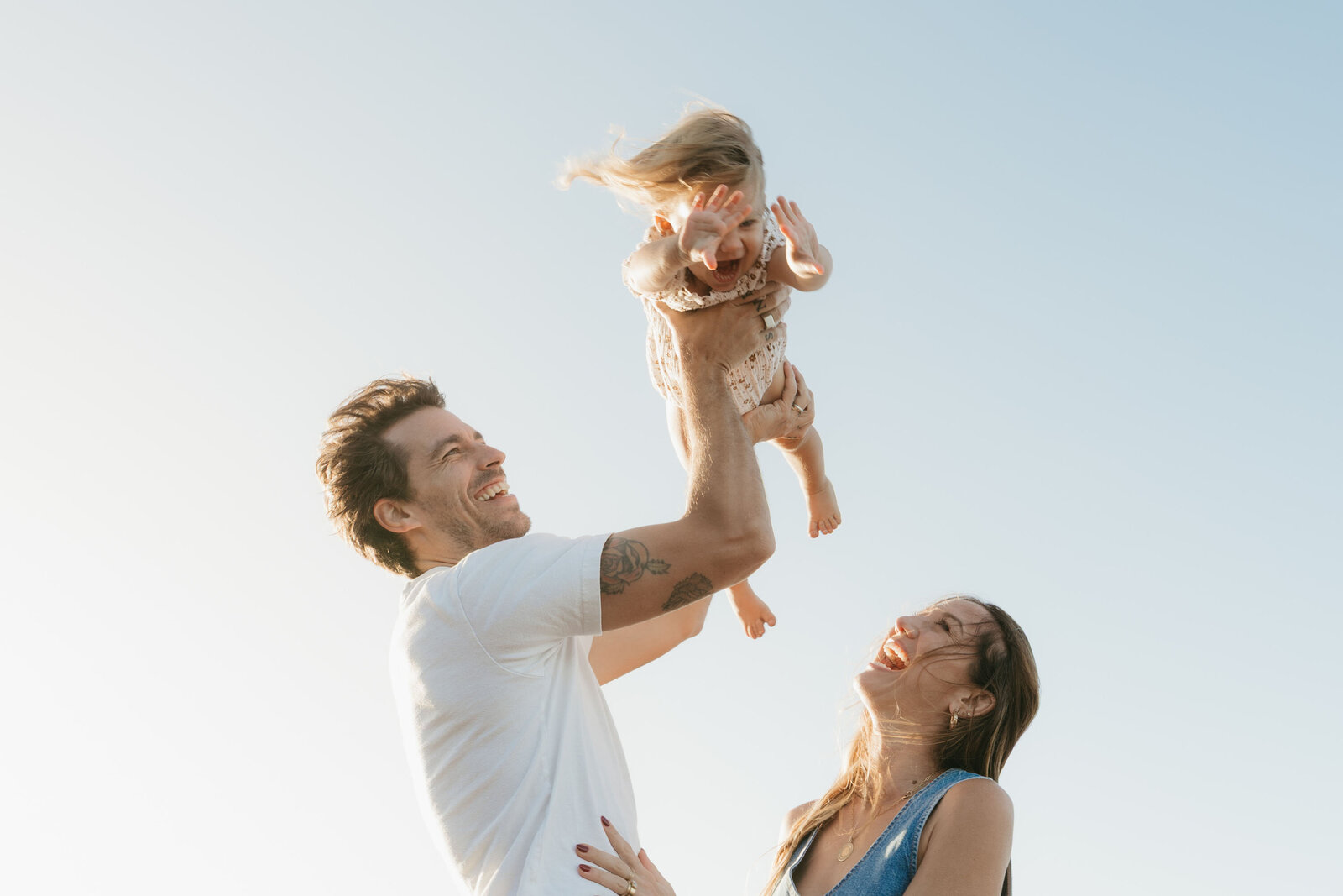Playing naturally during a styled Maui family photography session, ocean and sunset backdrop.