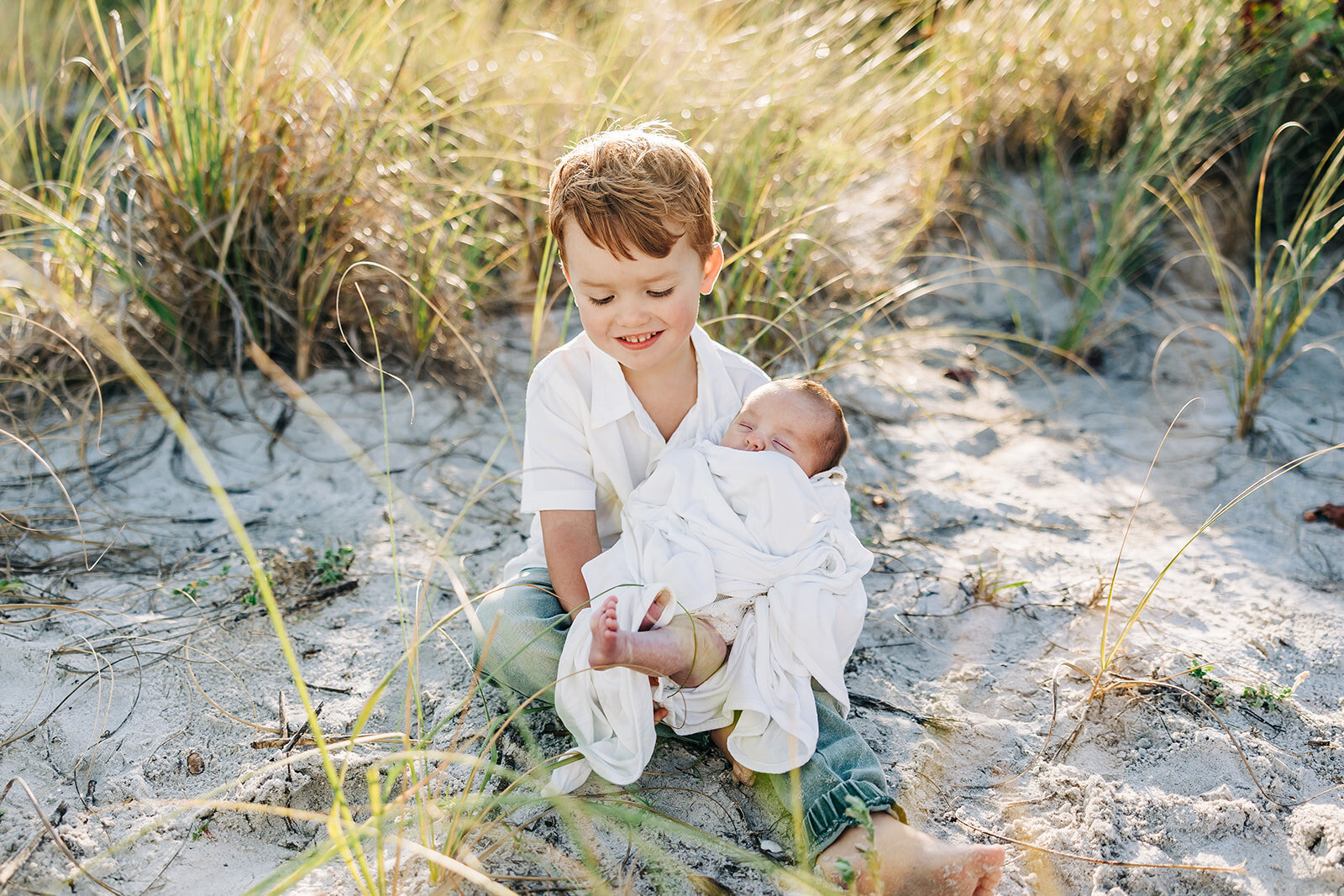 A family heirloom. A little boy holding his baby brother on the beach in st. pete.