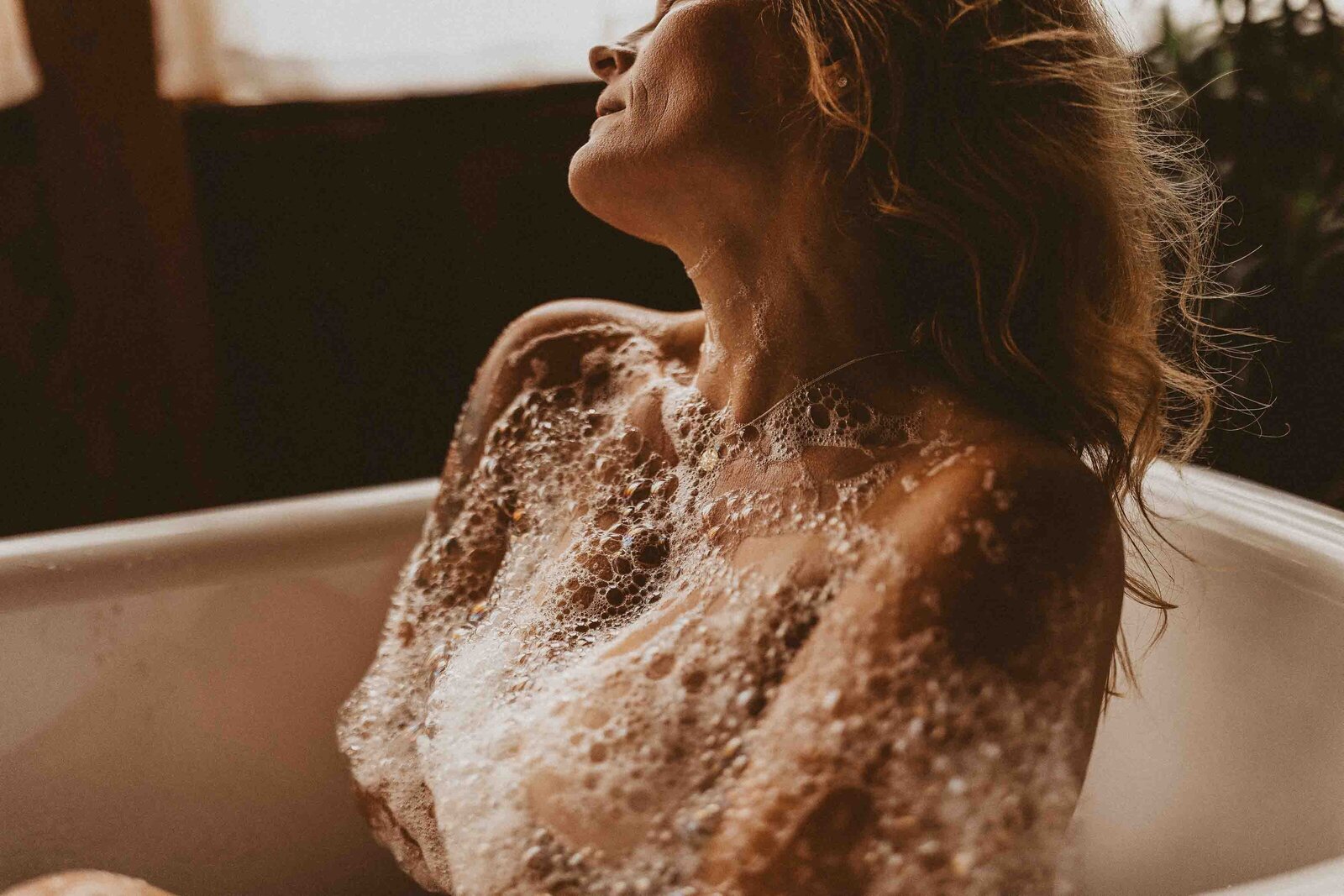woman in a bathtub with bubbles in her body