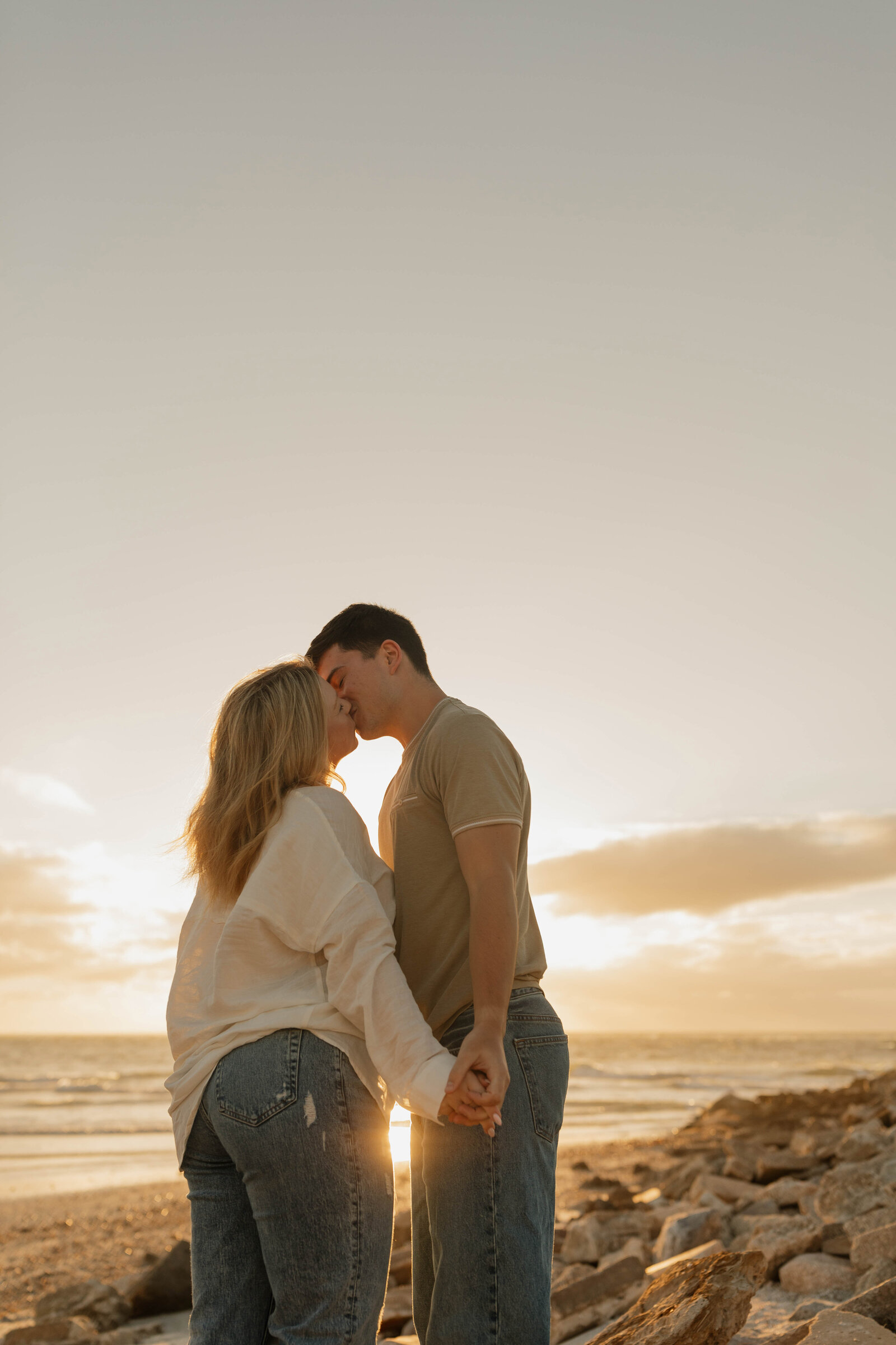 Couple laughing together during a fun and playful photography session on a beach in Florida.