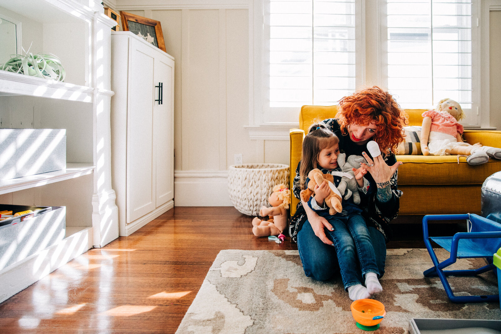 mom sitting on floor in living with young daughter