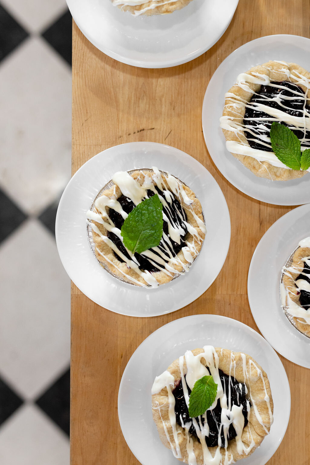 individual blueberry pie with white drizzle and mint