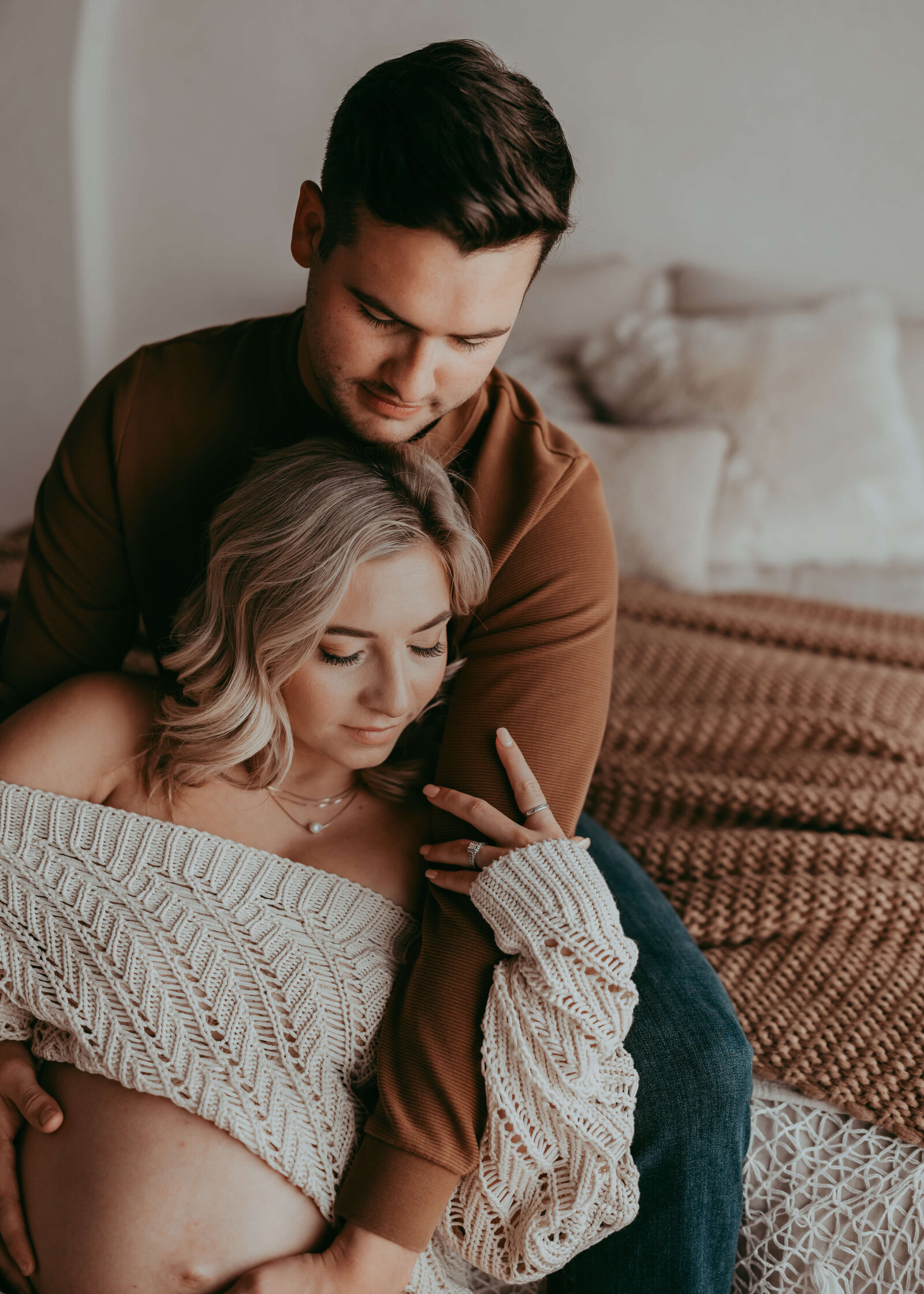 husband holds expectant wife's pregnant tummy