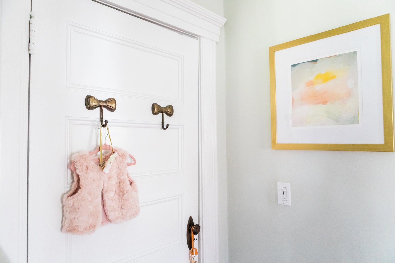 Two bow hooks on the back of a nursery door.