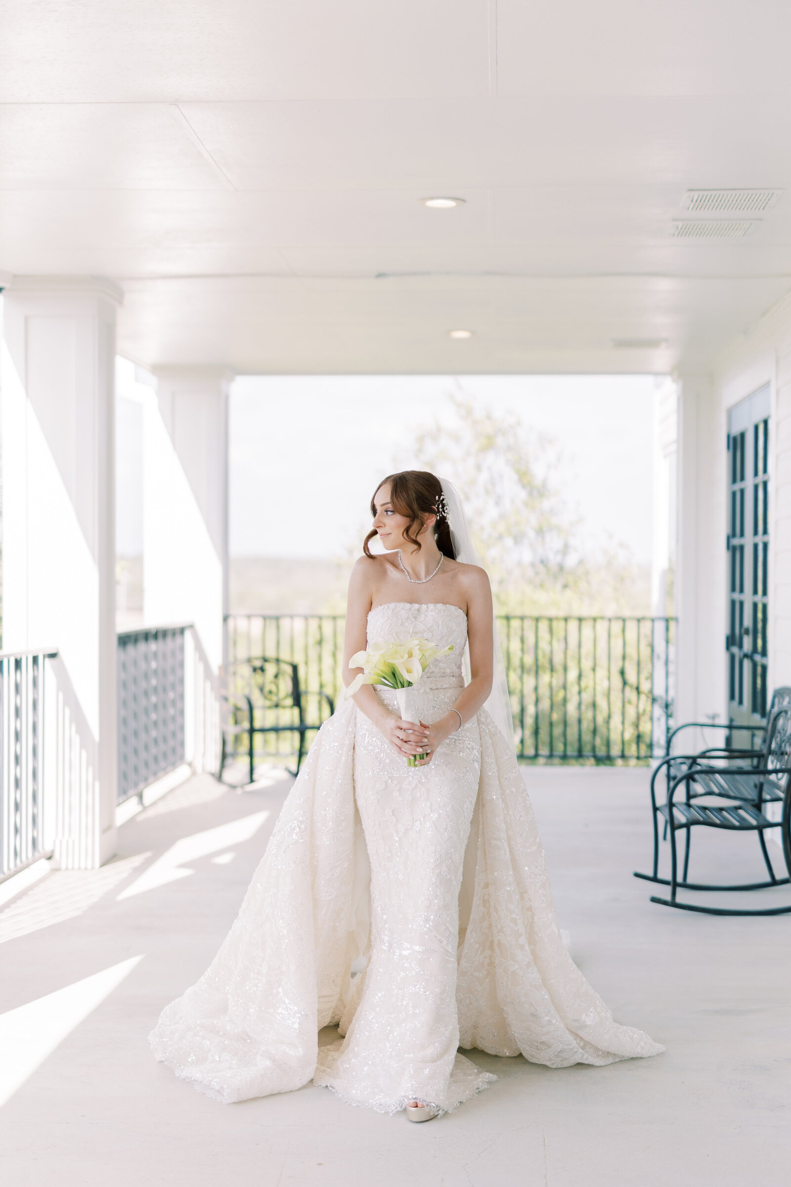 A bride poses on the Kendall Point wrap-around porch.