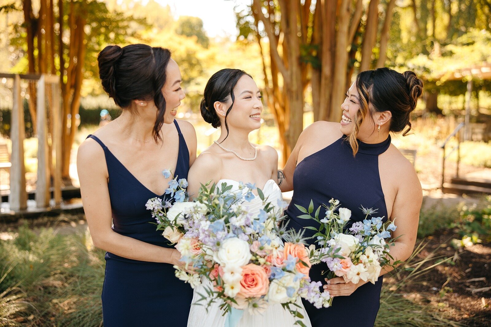 Bride with bridesmaids holding colorful bouquets outdoors