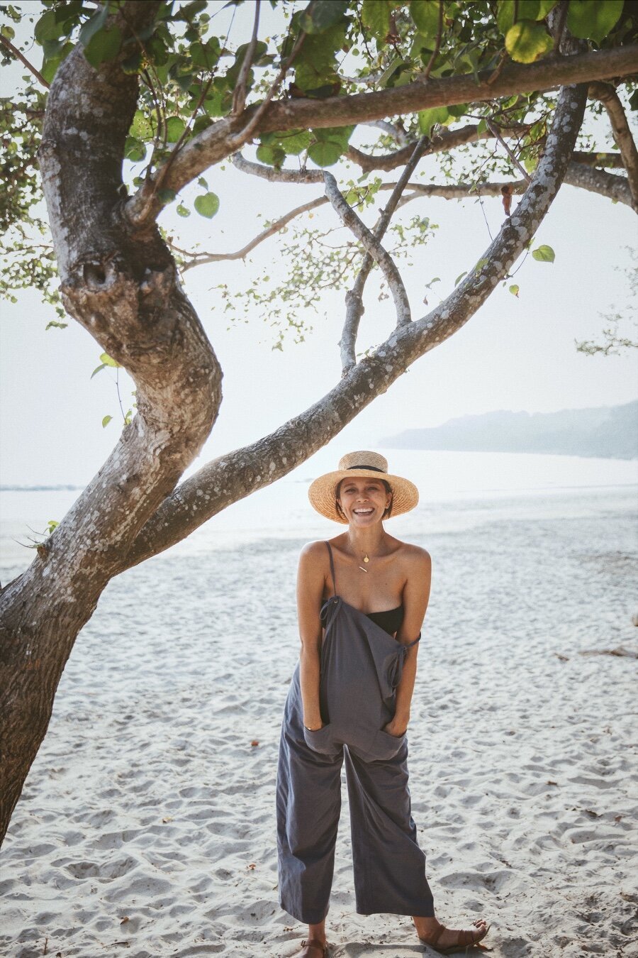Cara on the beach in overalls and a sun hat for her blog in Vogue Hong Kong