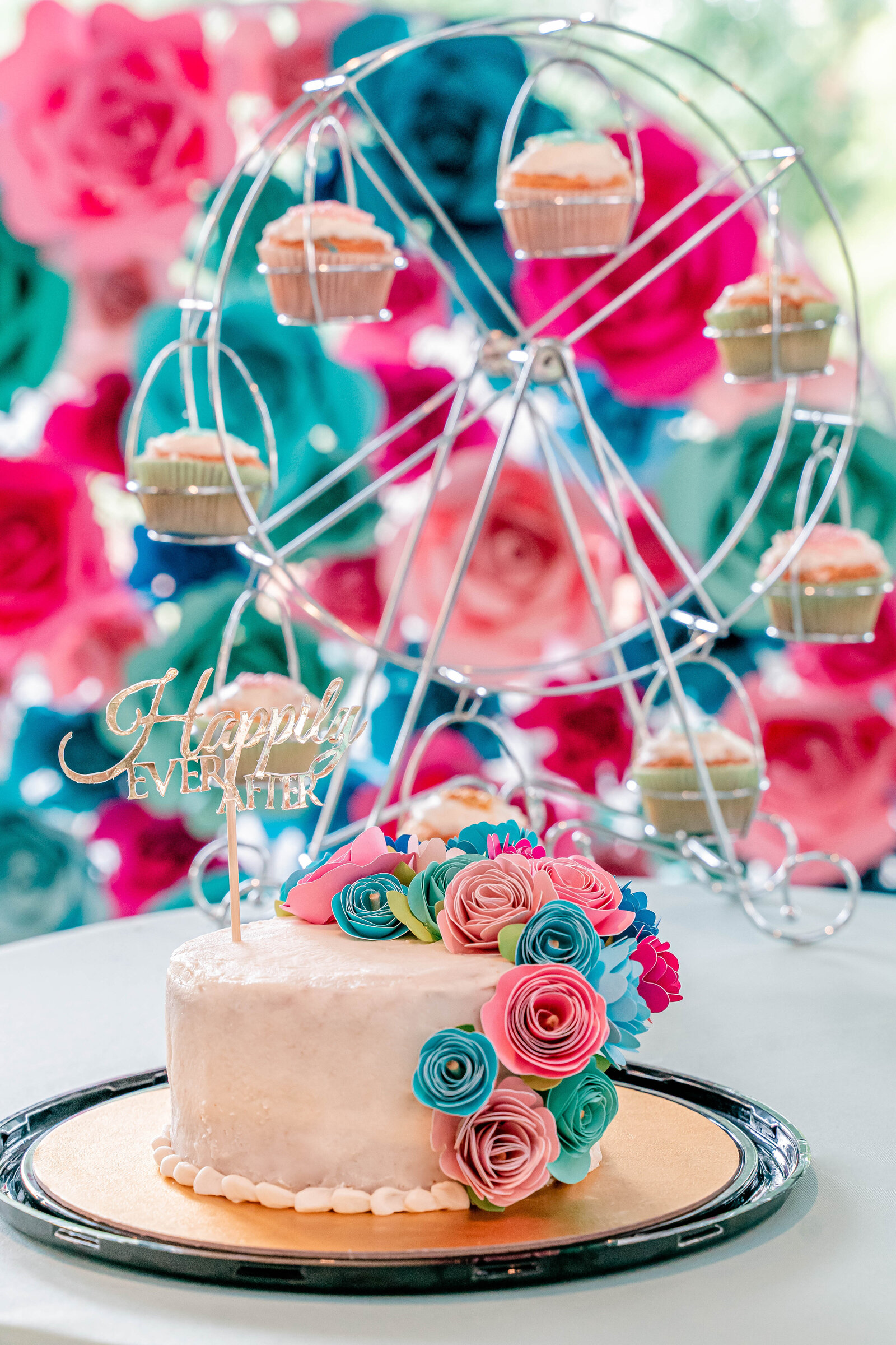 A cake covered in colorful paper flowers during a whimsical wedding at Glen Echo Park in Washington DC