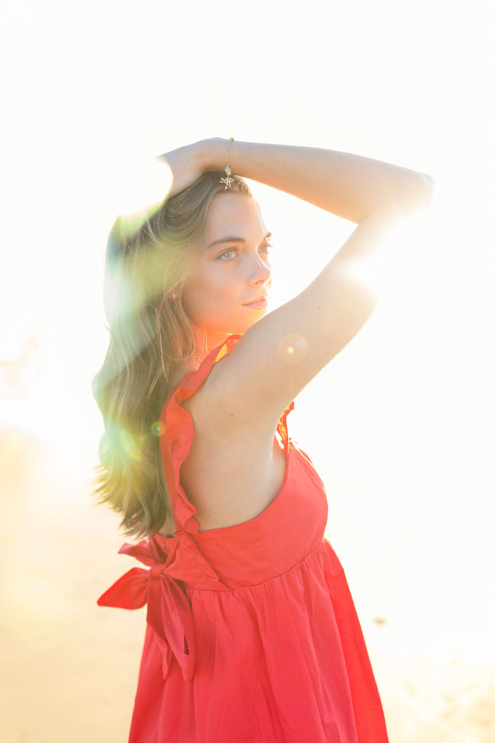 brunette wearing red dress posing for a picture