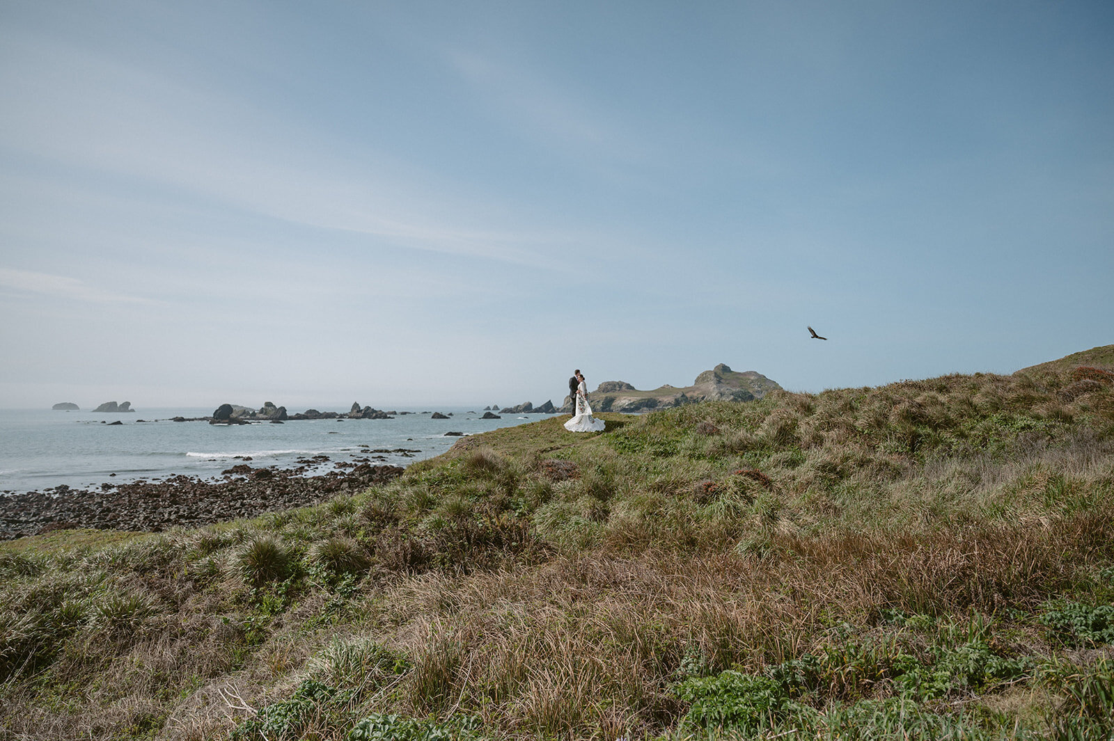Couple stand on the coast