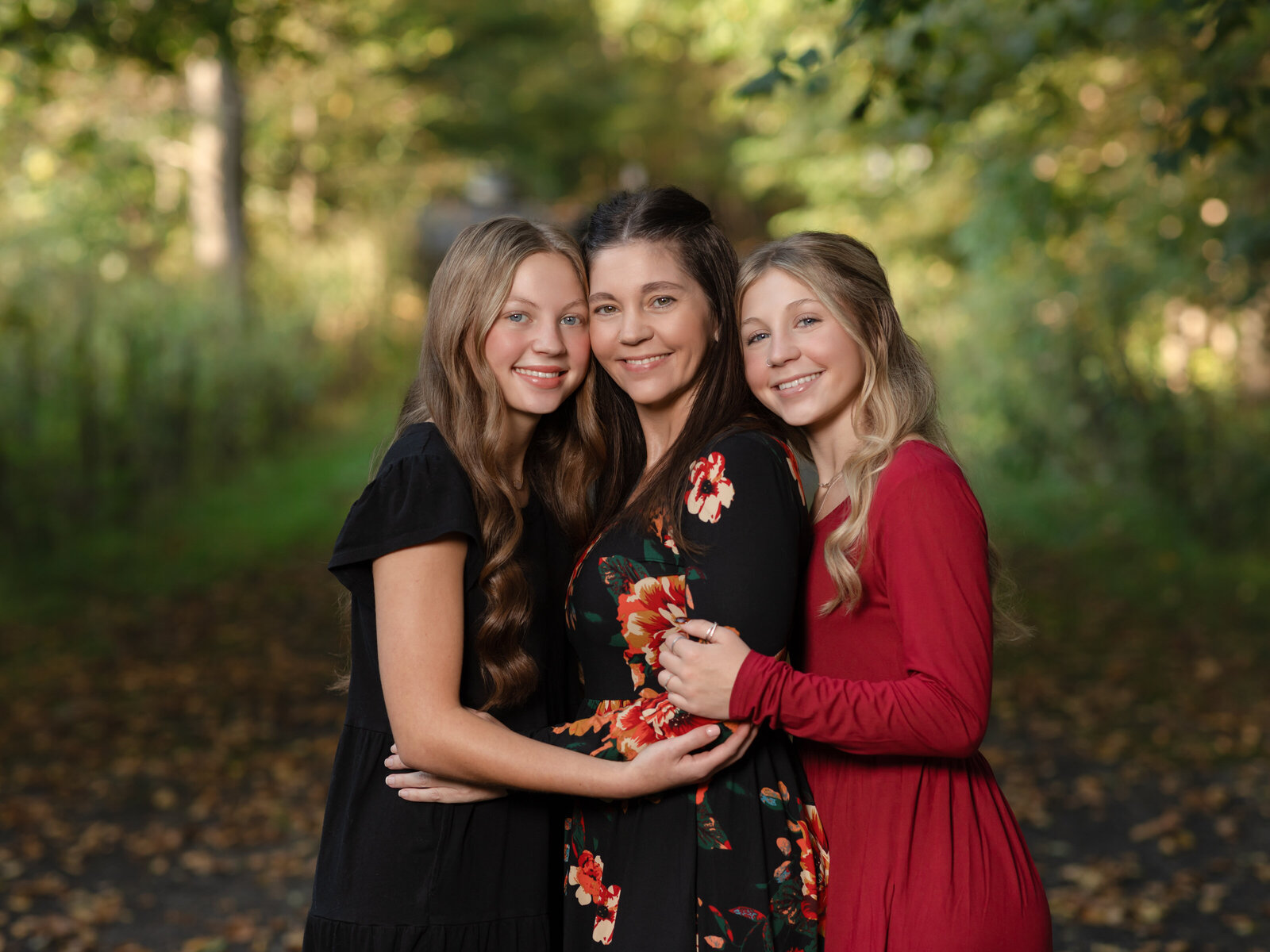 mom and two daughters hugging for family photos at park cleveland family photography