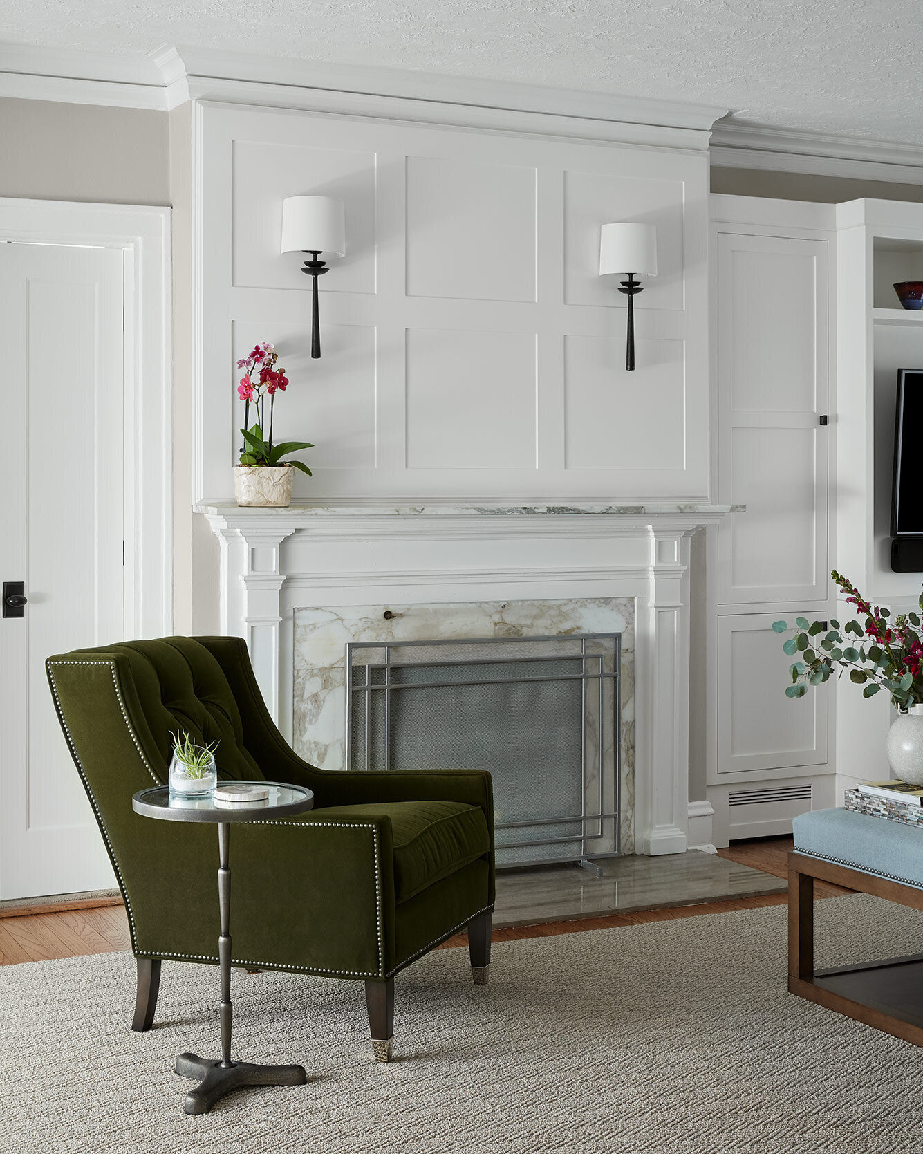 Olive green chair in front of a white fireplace