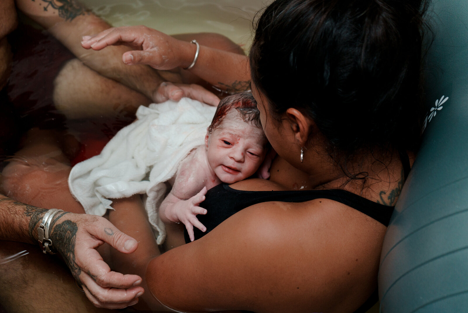 Mother and baby in birth tub after birth in a birth center located in West Palm Beach