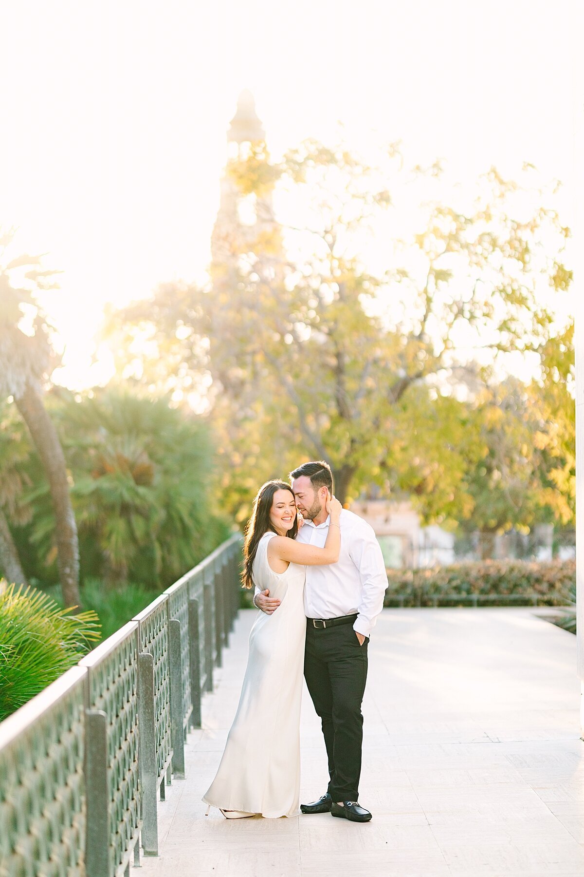 Engaged couple smiling at one another at Balboa Park in San Diego, California.