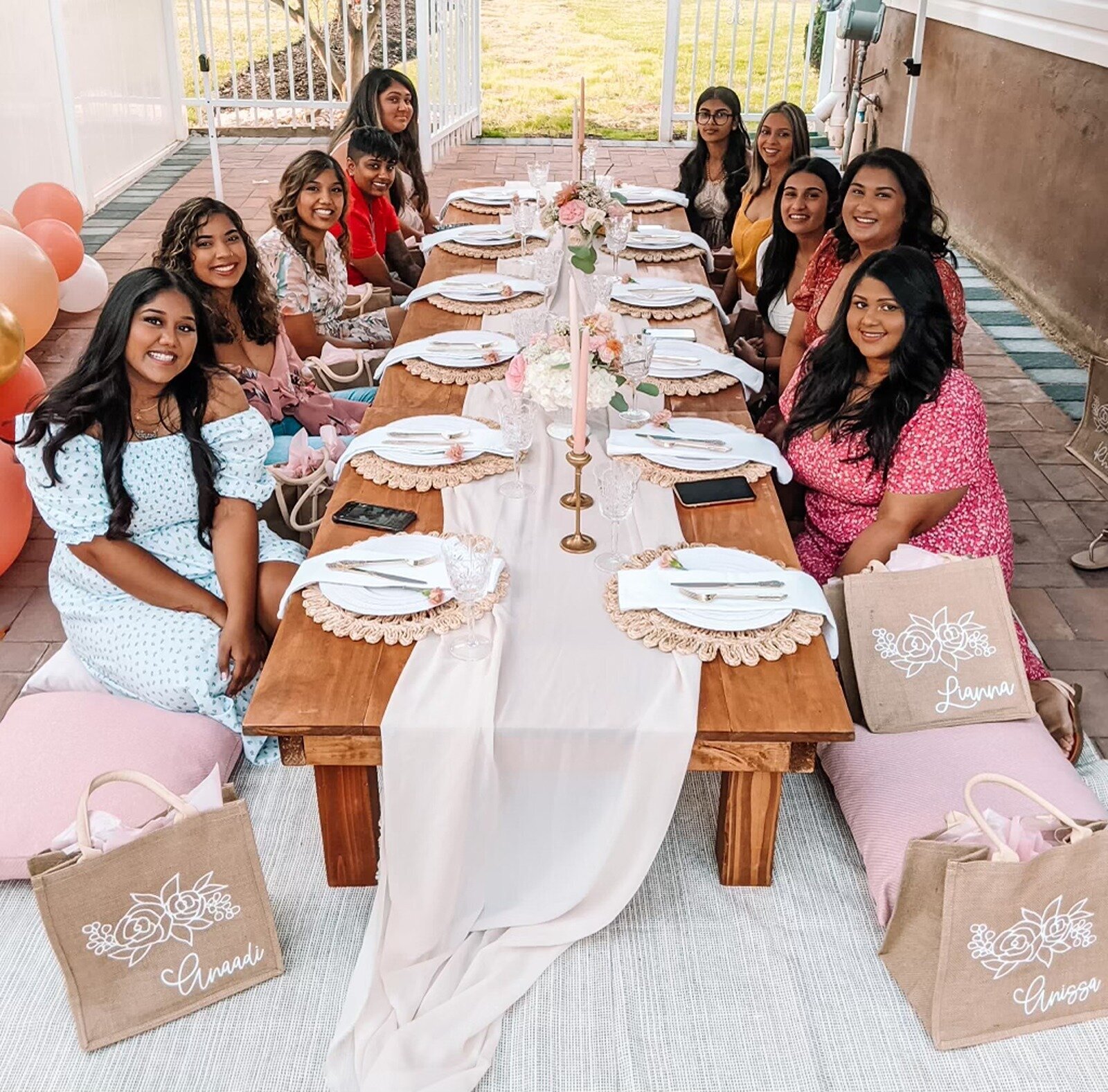 Bridal shower celebration with styled wooden tables, blush pink accents, and personalized guest gift bags, designed by Yours Truly, a wedding planner and designer in New Jersey.