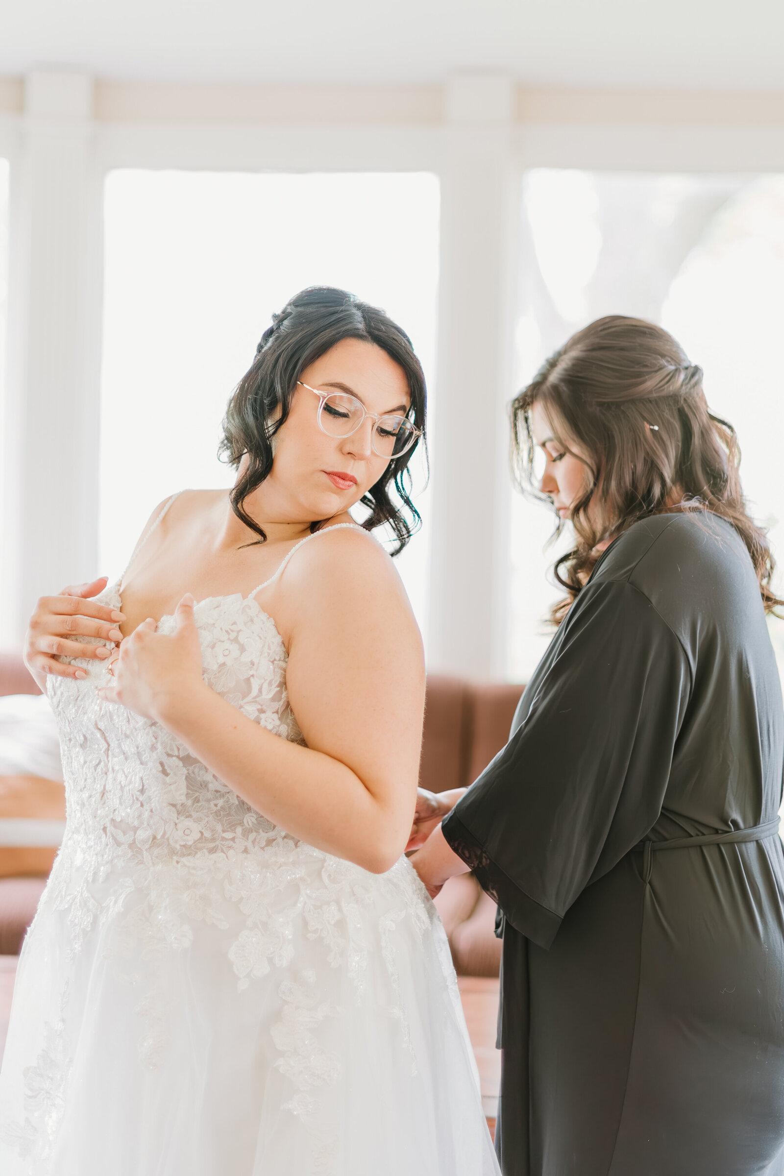 Lexington bride getting zipped into dress on her wedding day