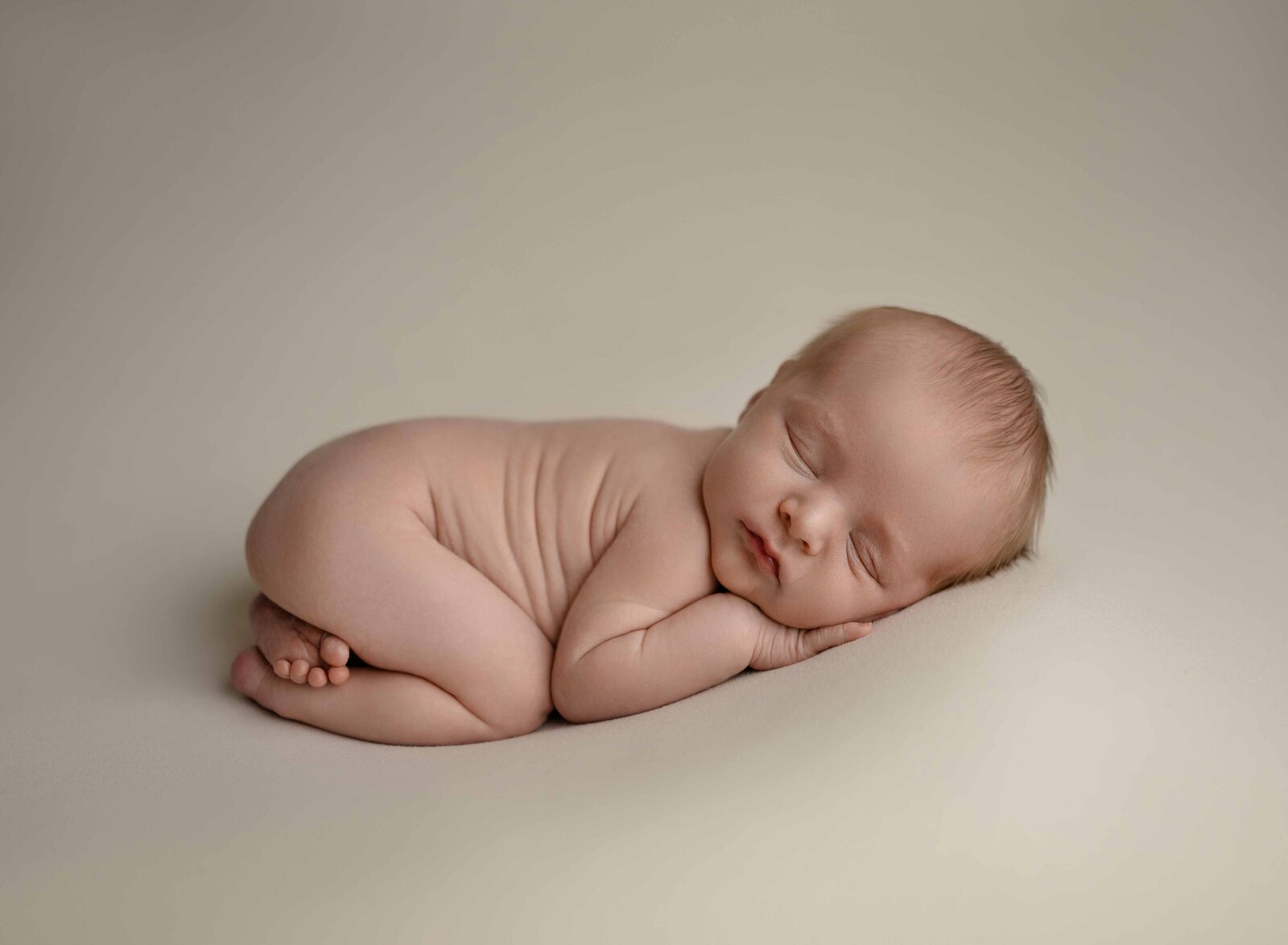 naked baby boy sleeping on his tummy with bum up in the air. Photographed at newborn photo studio near Atlanta, GA.