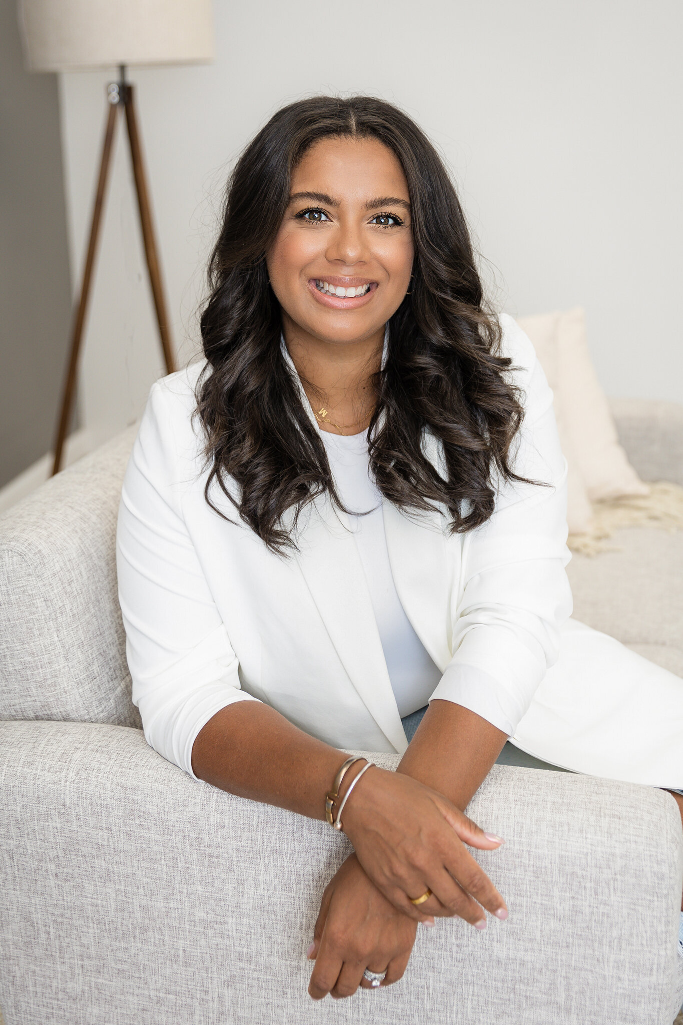 Woman in white blazer top smiling at camera