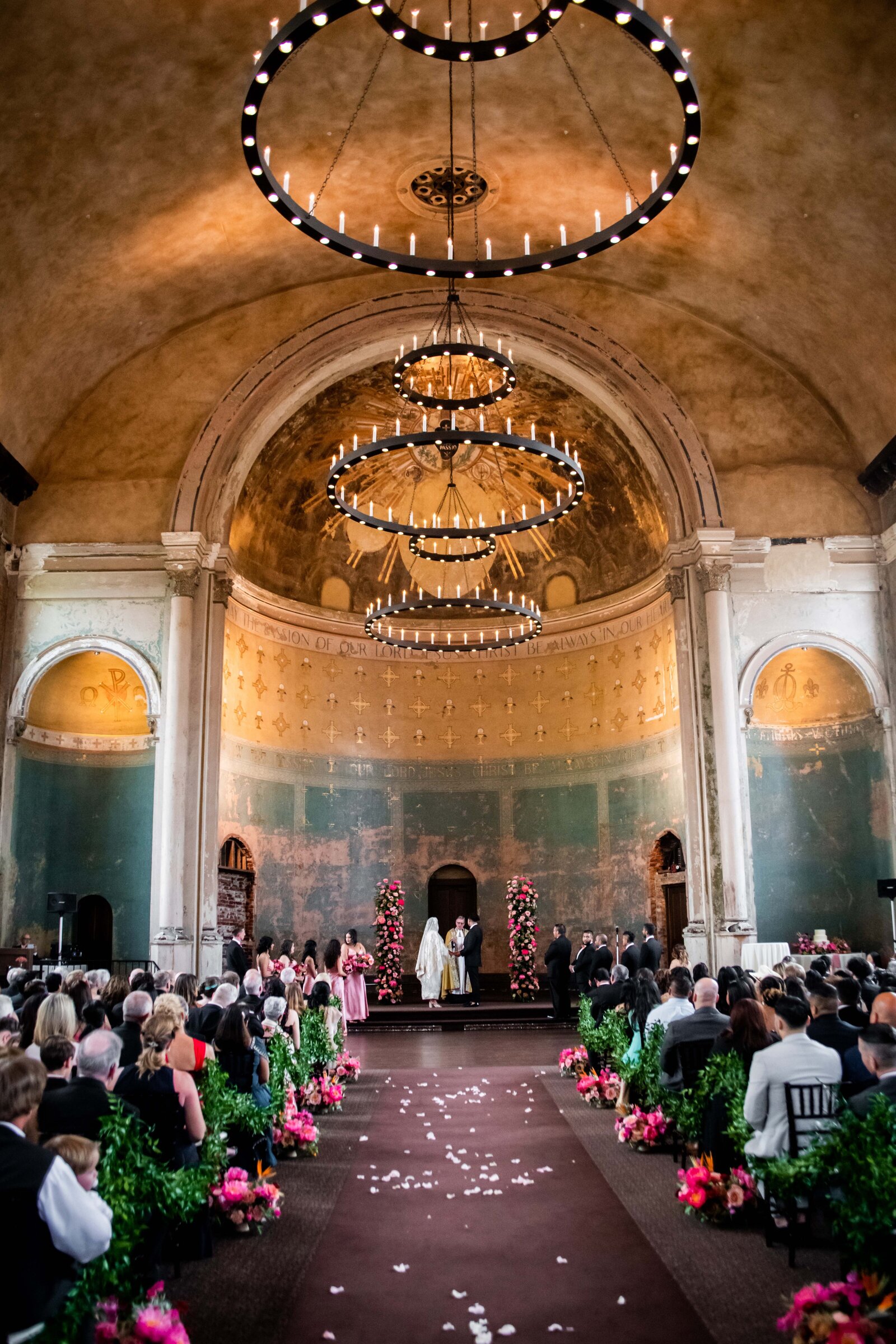 Step into the awe-inspiring ambiance of Mary Grace and Martin's wedding ceremony held at the stunning Monastery Event Center. This image captures the couple exchanging vows amidst the center's opulent architectural details, featuring soaring ceilings and intricate stonework that echo the grandeur of their special day. Perfect for couples dreaming of a lavish ceremony or those who appreciate the majestic beauty of historic venues, this photograph showcases how a spectacular setting can elevate the wedding experience to extraordinary heights.