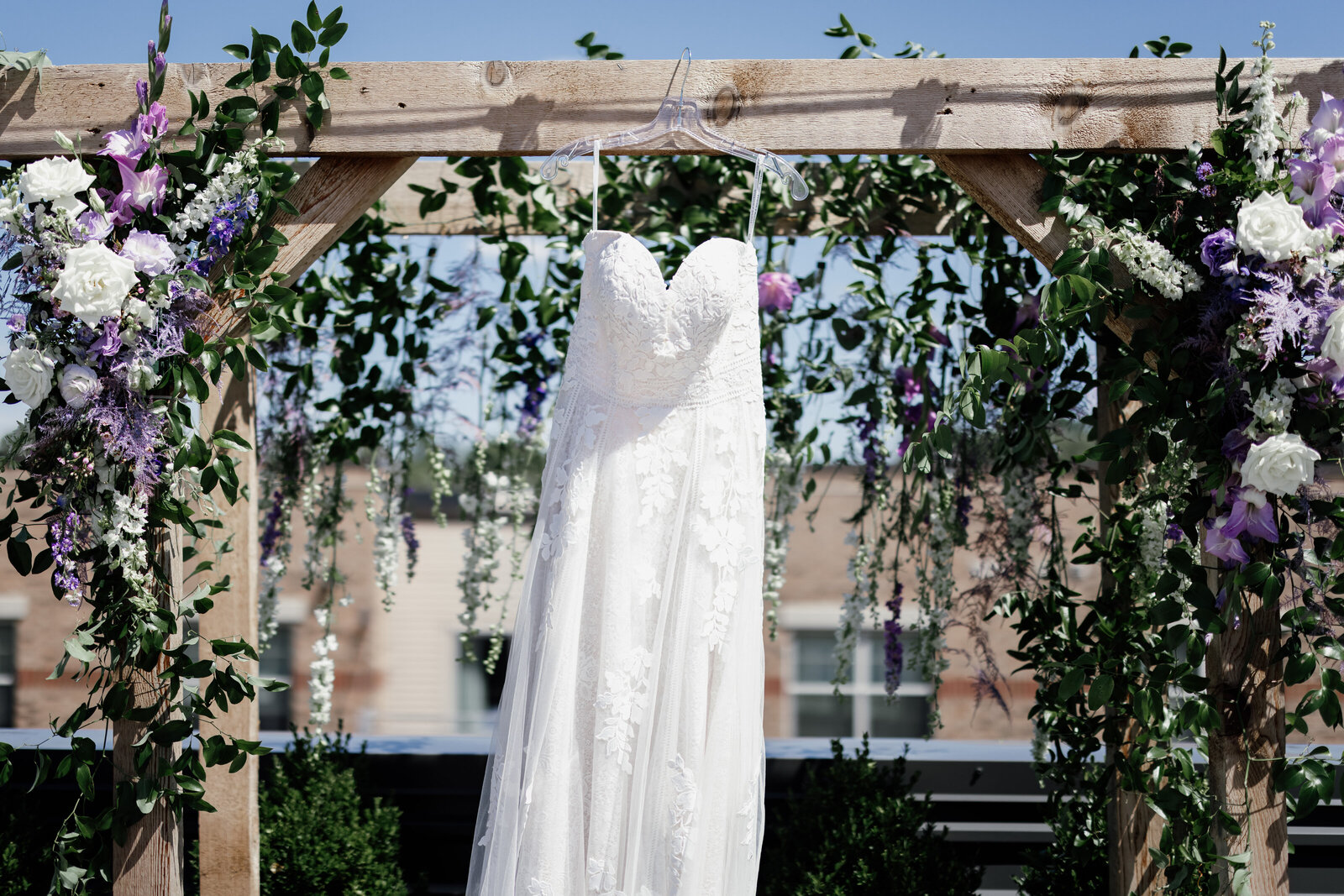 Wedding dress hung on a bridal arch with flowers