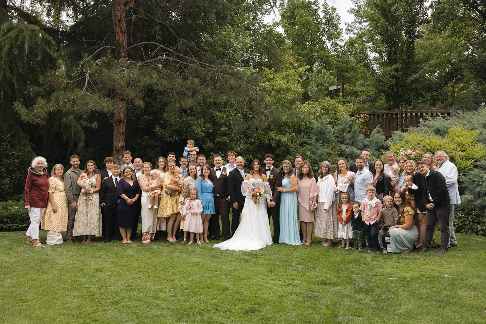 Big family photo with the bride and groom on the lawn