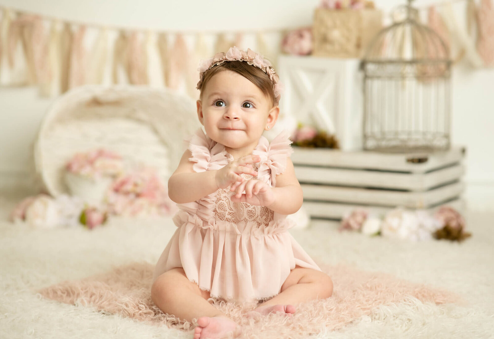 8 month old girl with pink romper and flowers