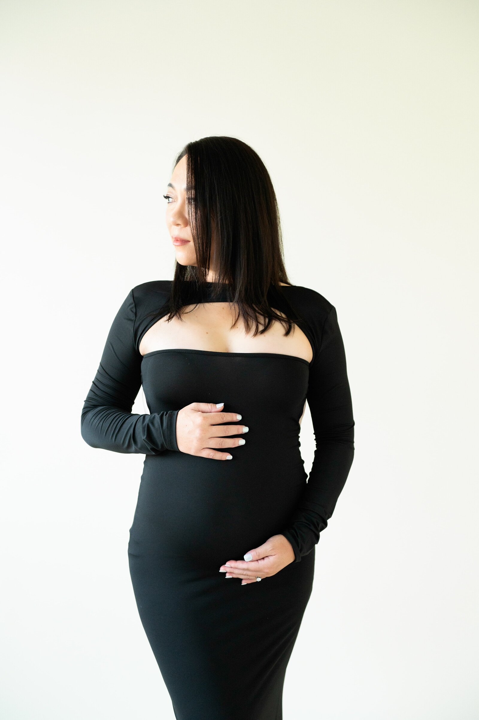woman looking to the side holding her pregnant belly