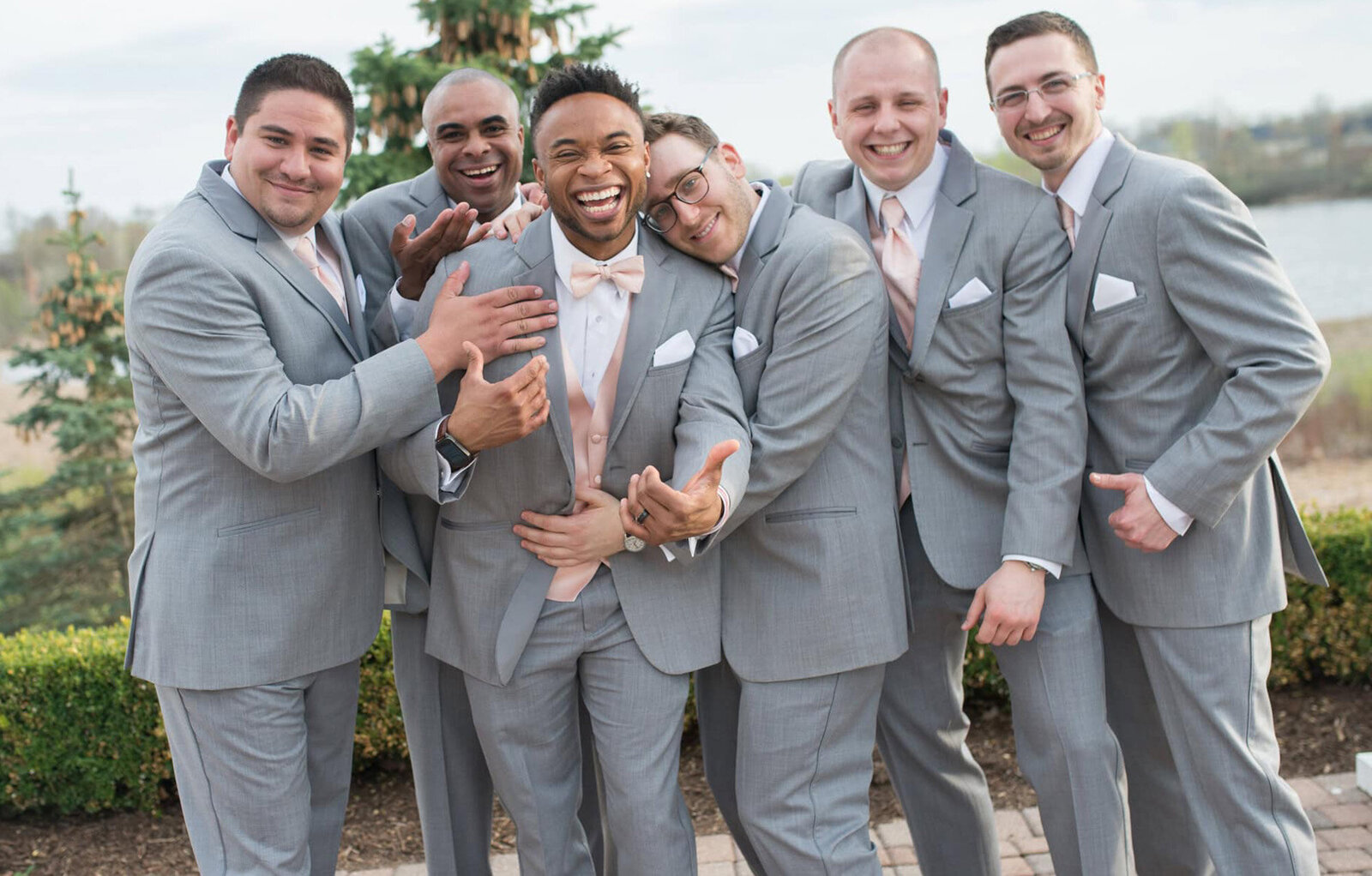 groomsmen huddle together laughing