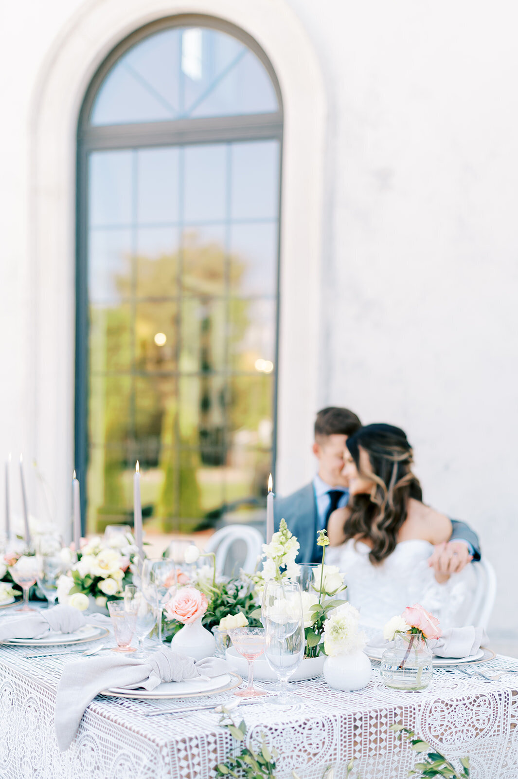 Chateau Des Fleurs Wedding with bride and groom sitting at reception table outside