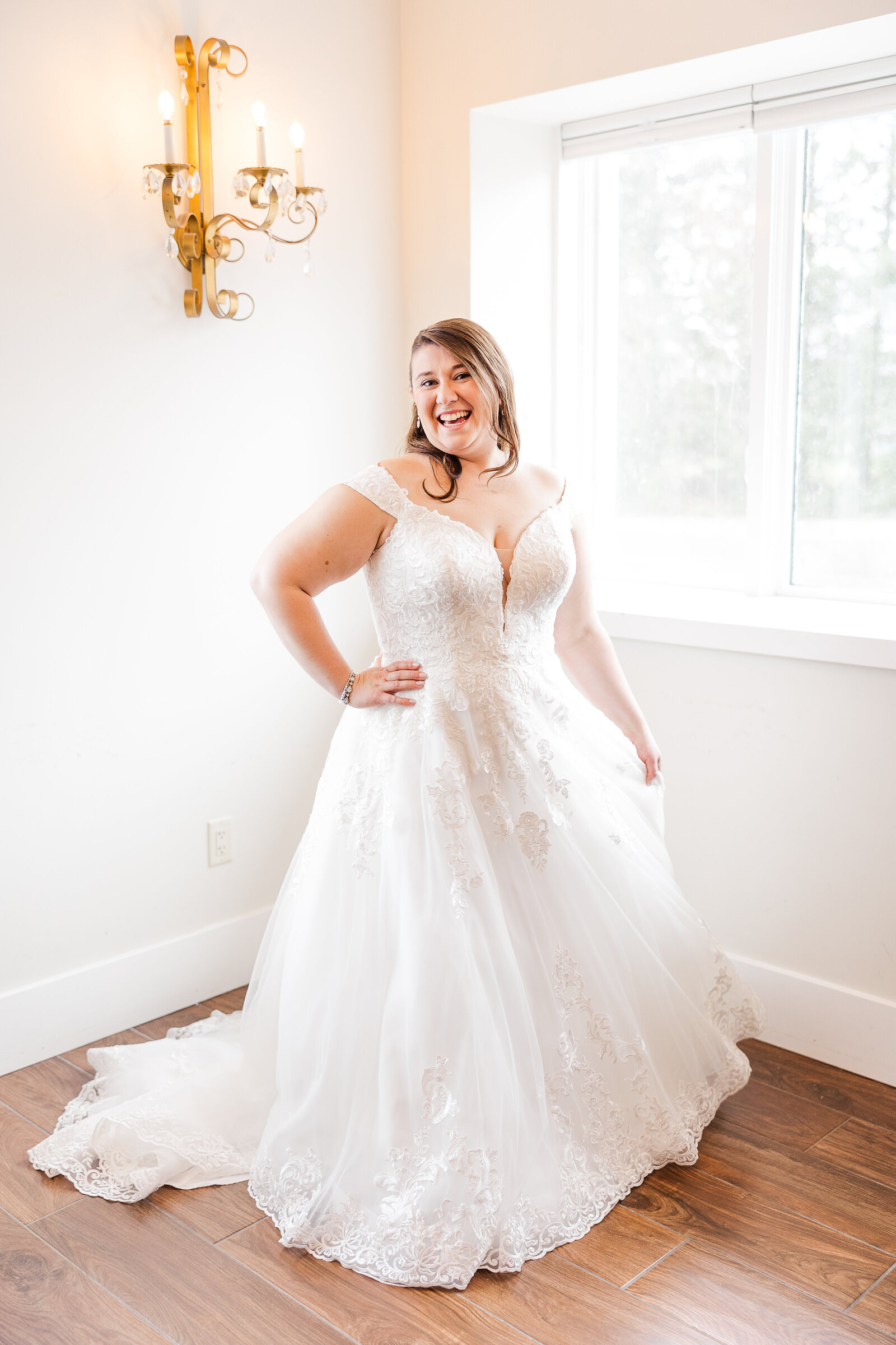 Bride smiling while holding her gown during wedding prep at Perona Farms in Andover, New Jersey