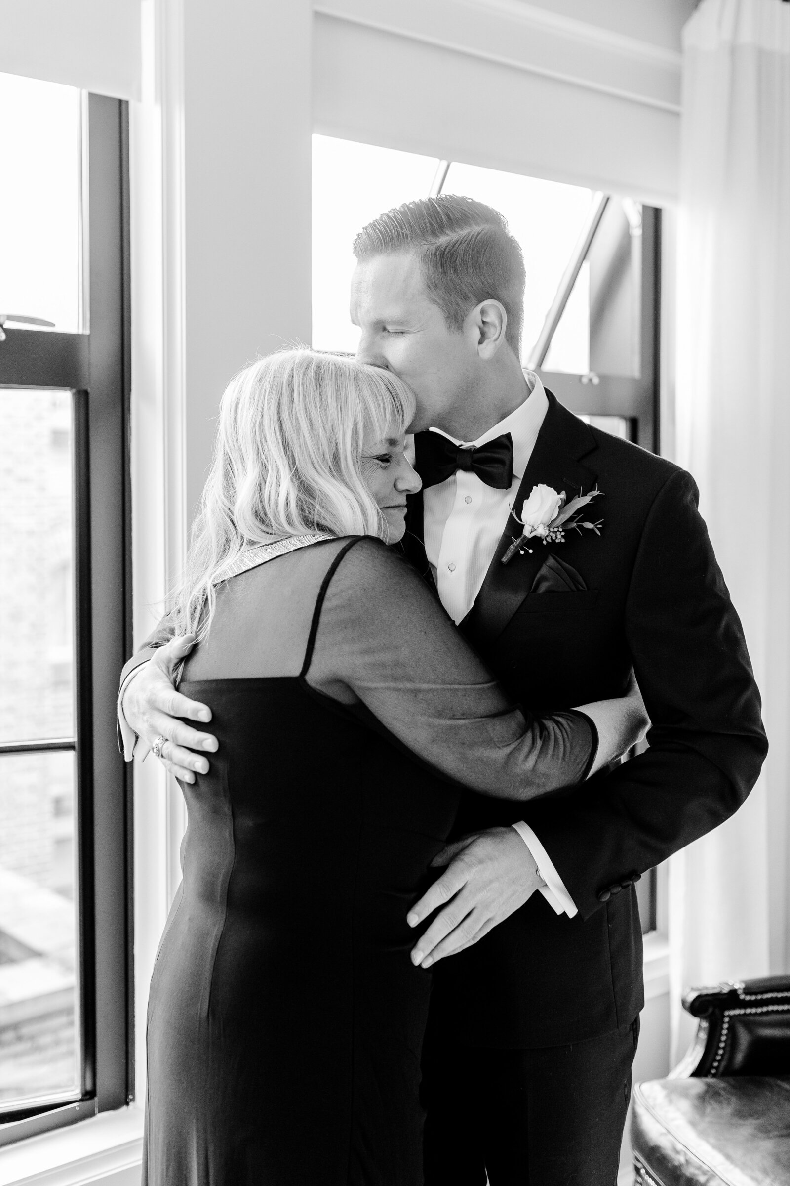 A groom giving his mom a kiss on the head before his Catholic wedding in Washington DC