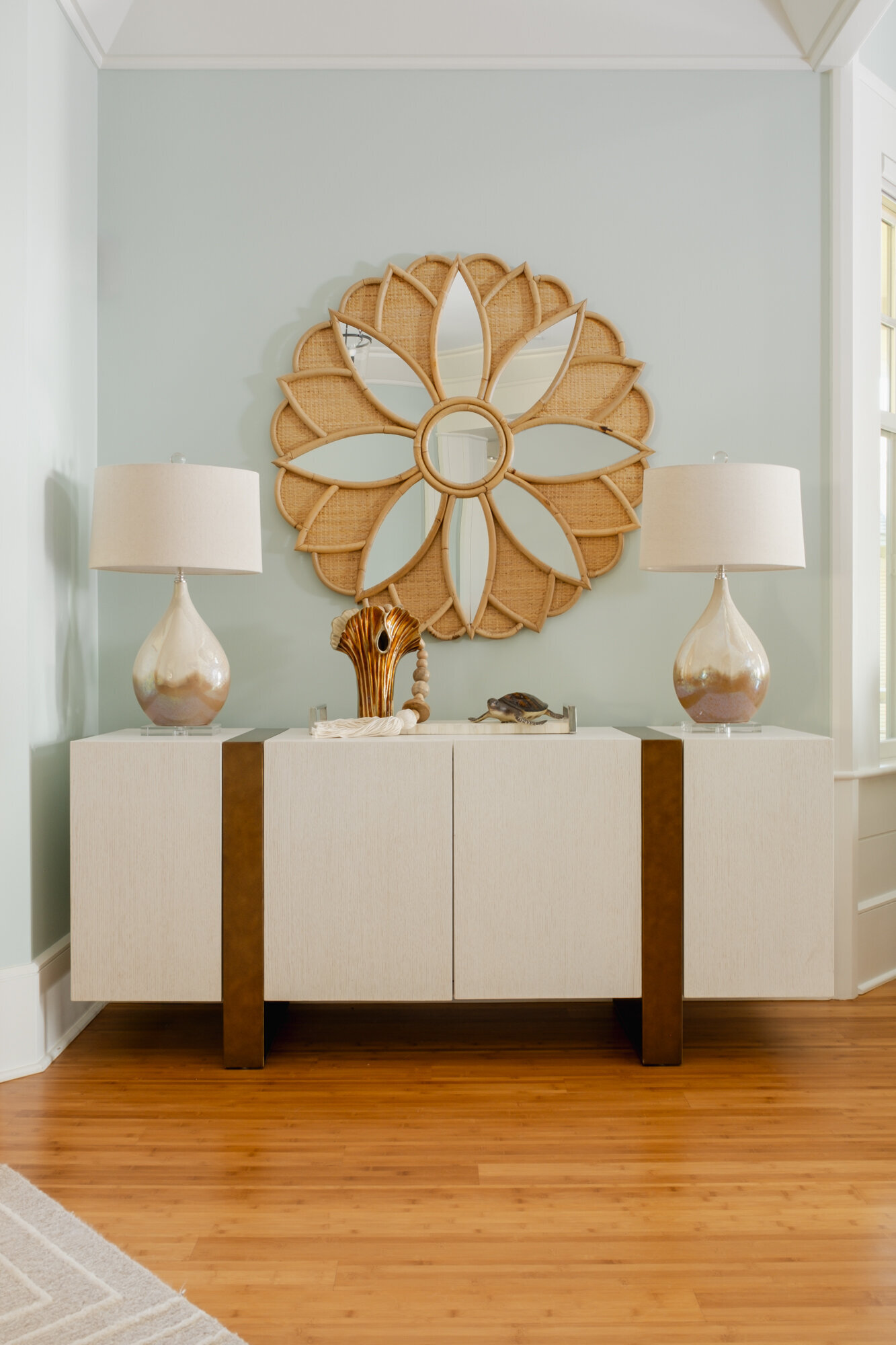 Living room remodel of a coastal home in Wilmington, NC, featuring serene, watery colors, updated flooring, and large windows framing stunning Intracoastal Waterway views."