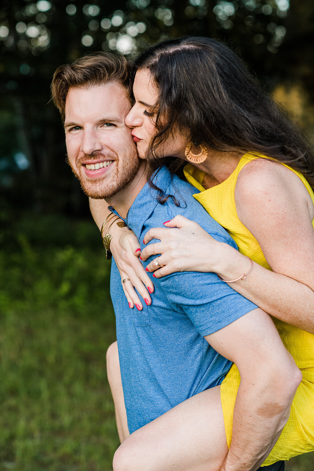 couple piggyback kiss on cheek
