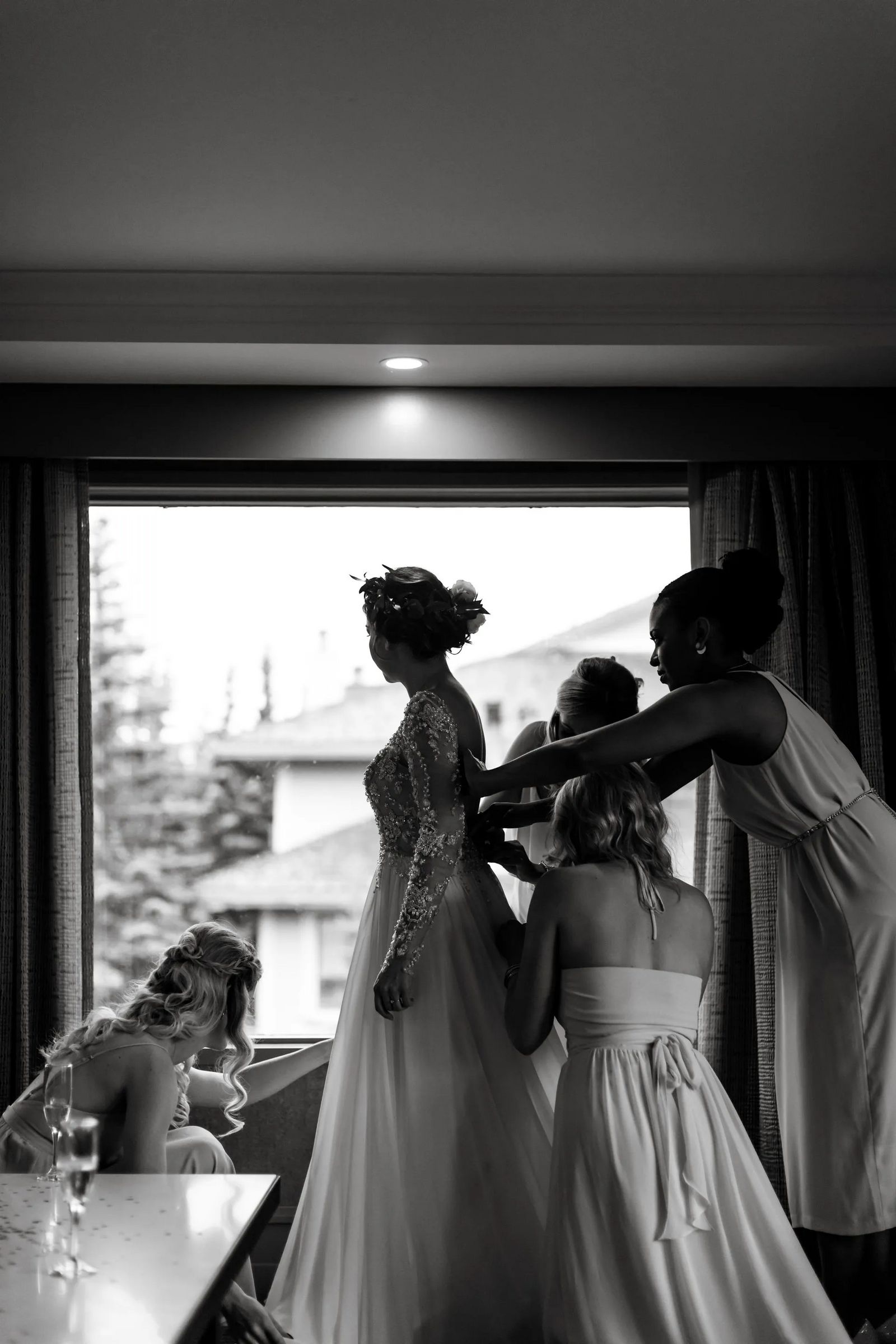 bridesmaids doing up bride's dress in Kananaskis