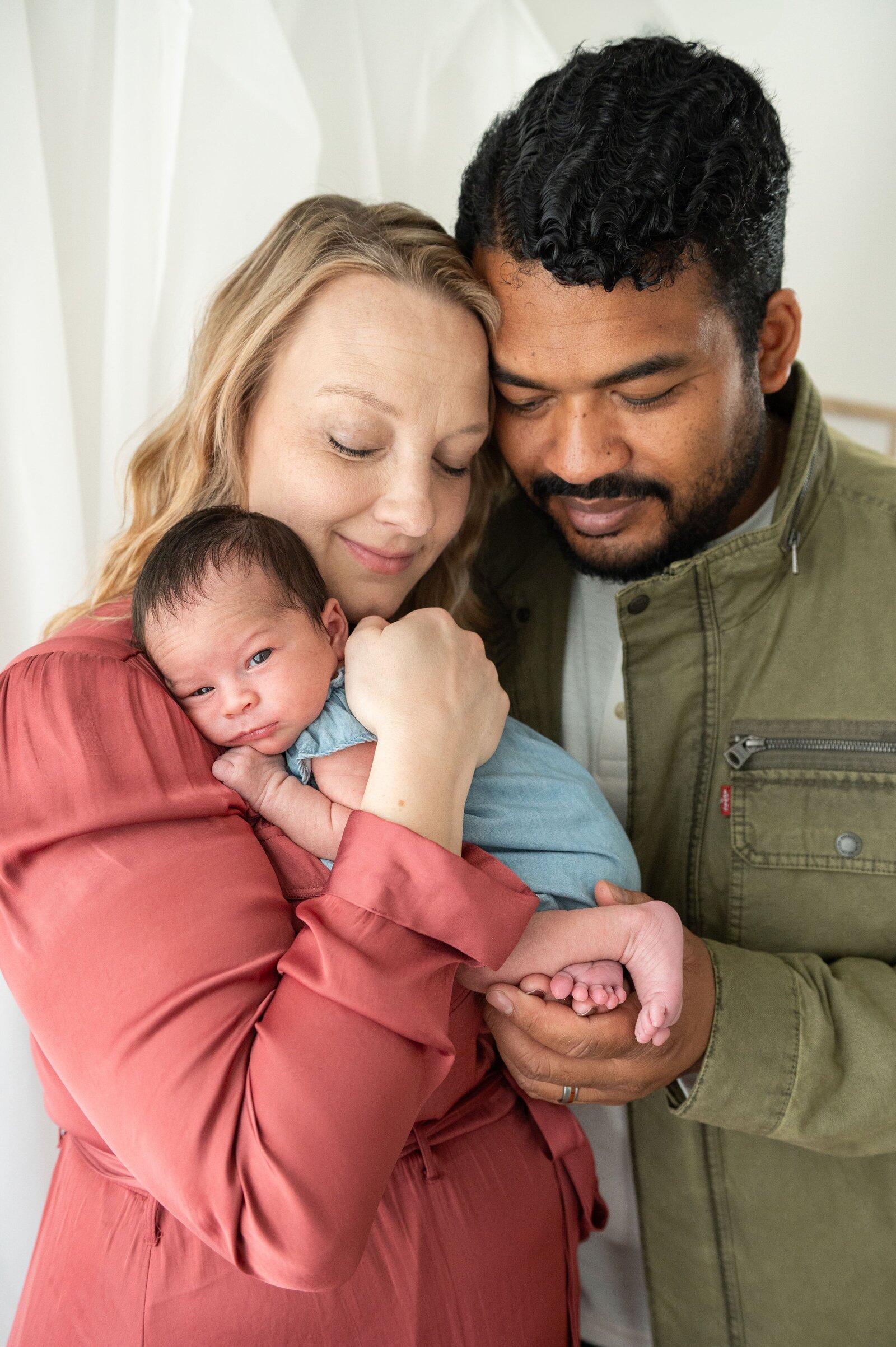 Close-up of newborn baby feet held gently by a parent during an in-home lifestyle session in Baltimore.

