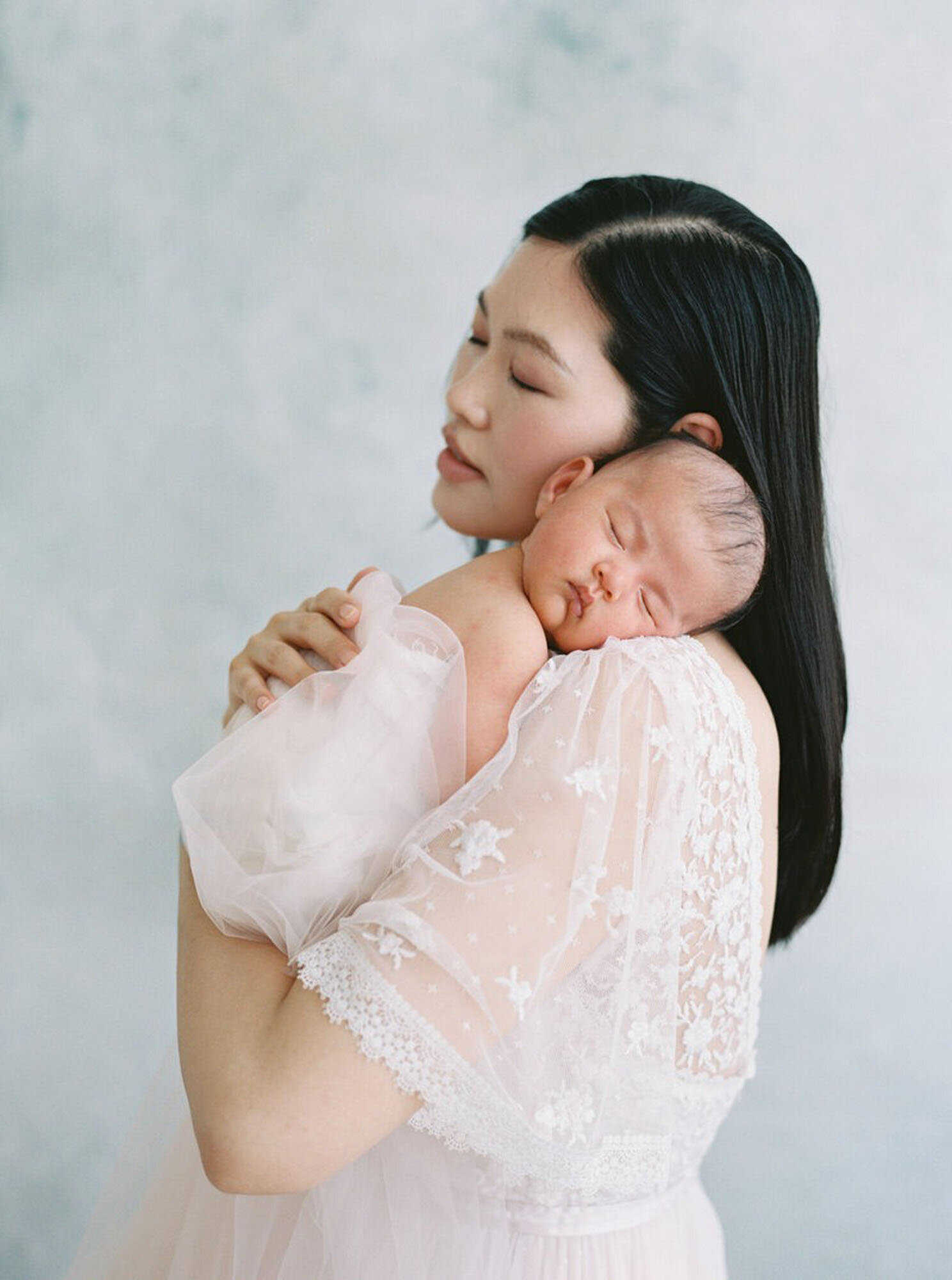 Mother holding newborn against her shoulder for Bay Area newborn photographer session.