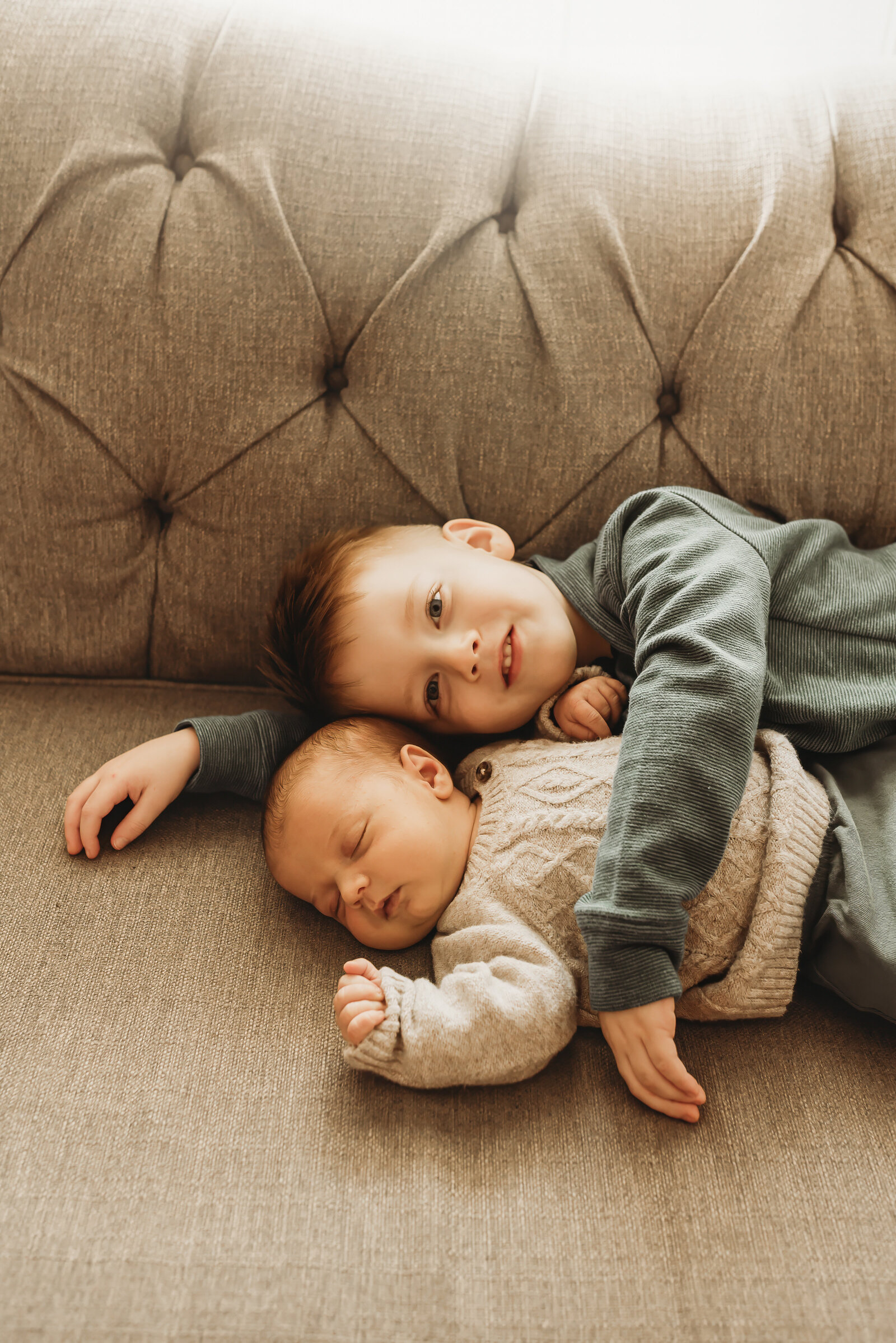Big brother snuggles his new best friend during an in-home newborn session in North Bismarck, ND
