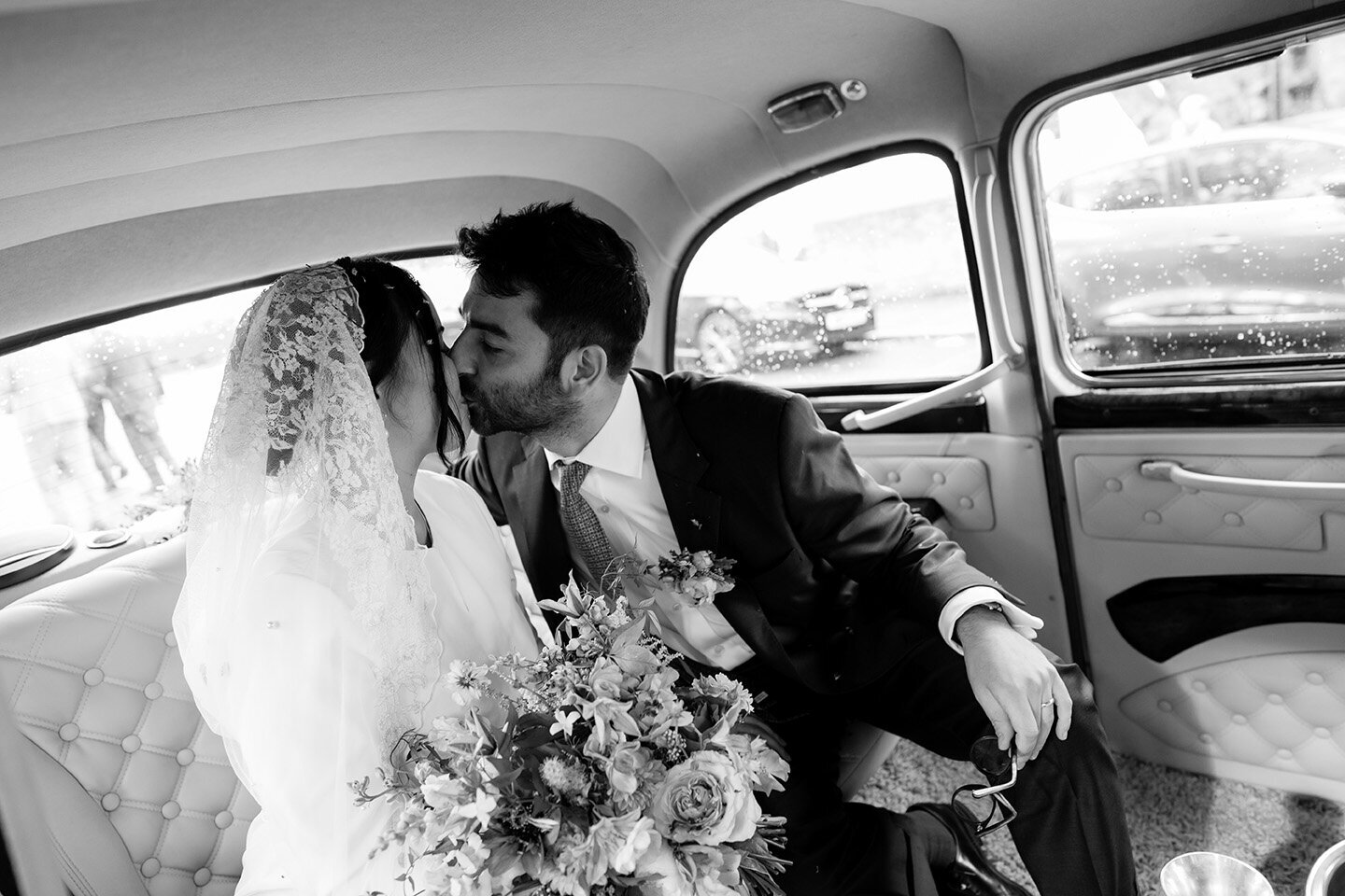 bride and groom kissing in taxi after their jewish muslim wedding ceremony in London
