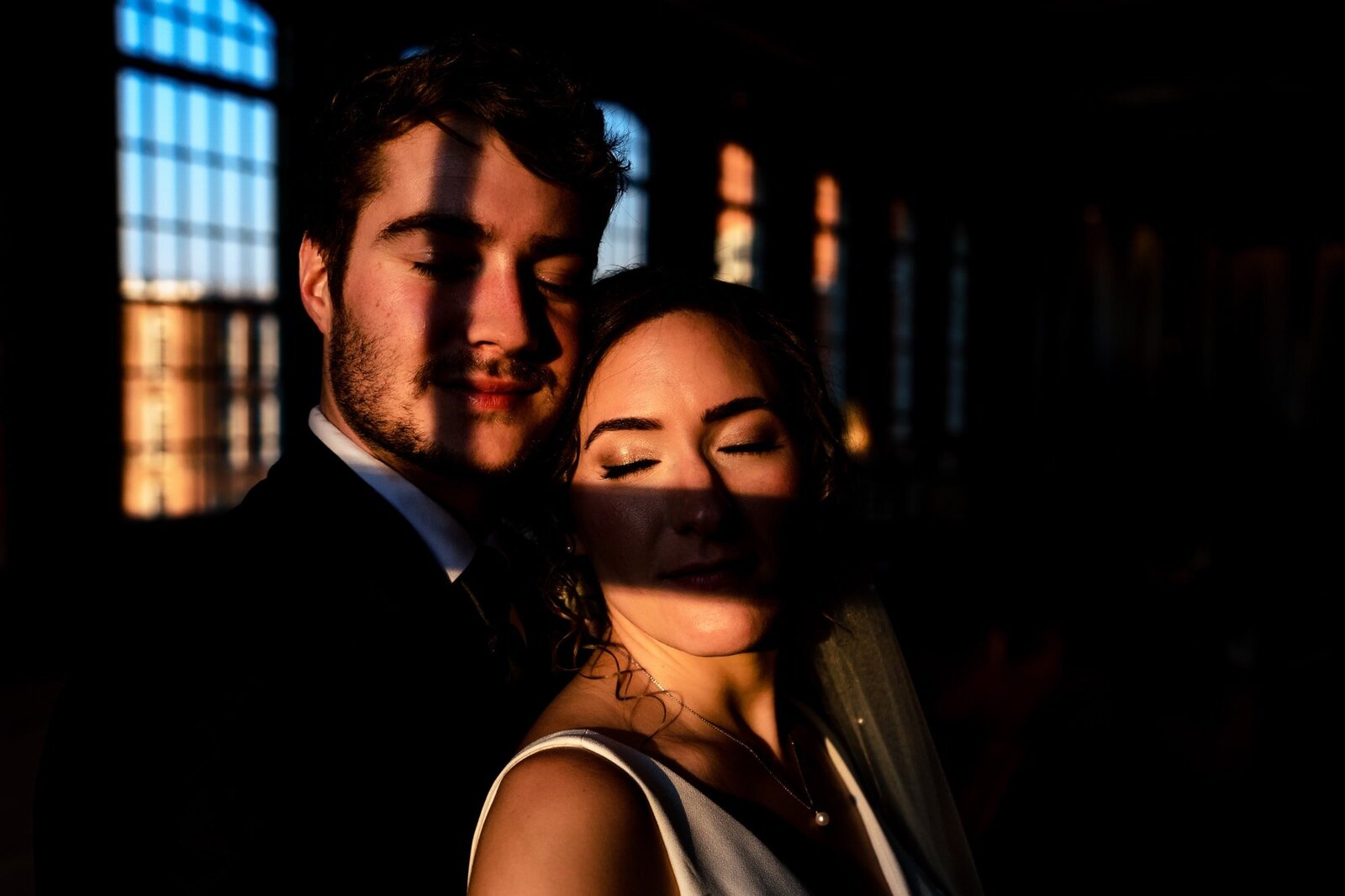 Dramatically lit portrait of a bride and groom at The Cotton Room