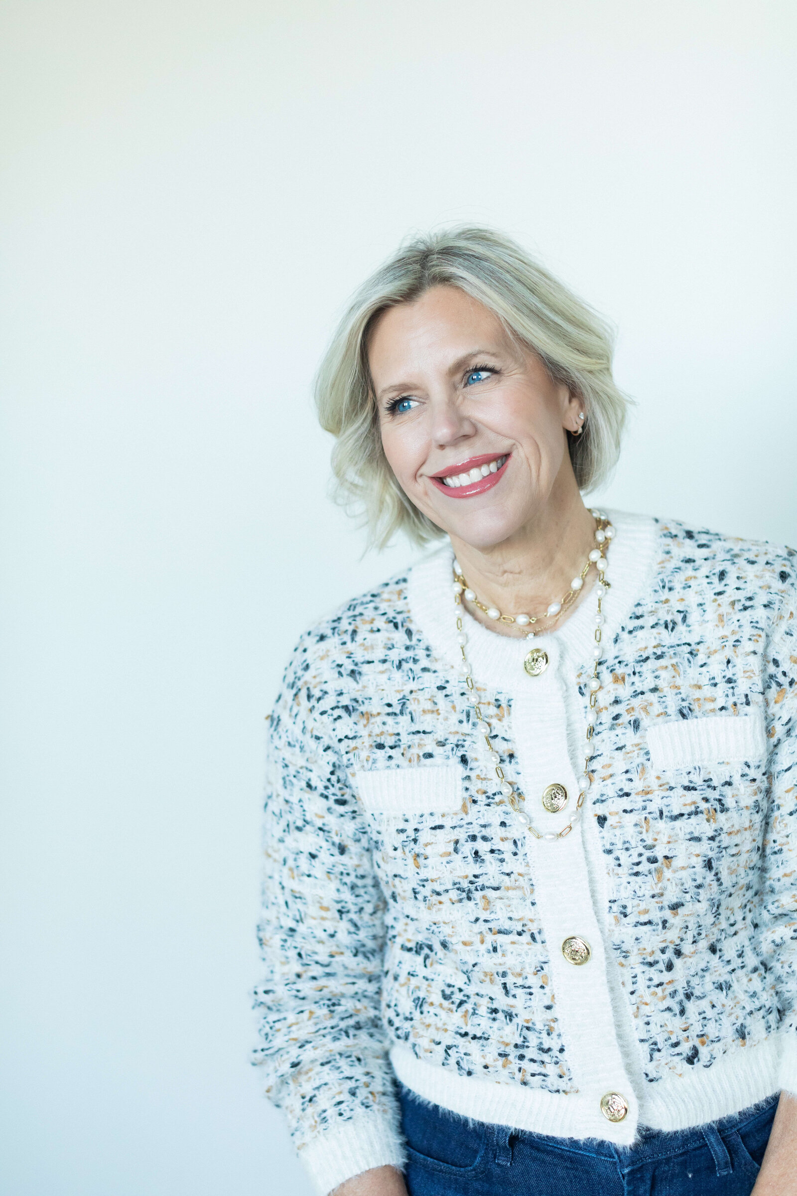 short blonde hair woman wearing plead blue and white top