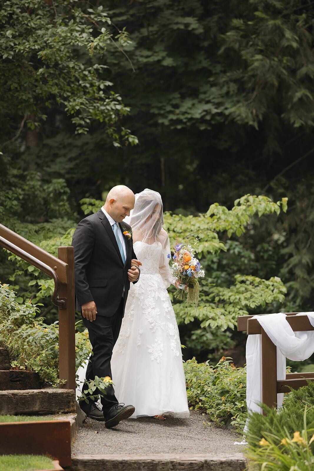 Bride walking down the garden steps with her dad at Applegate Christian Fellowship