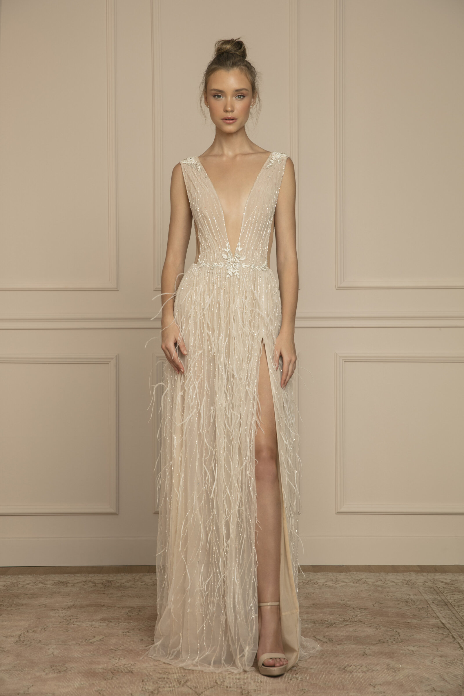 bride wearing nude feathered wedding dress with high slit