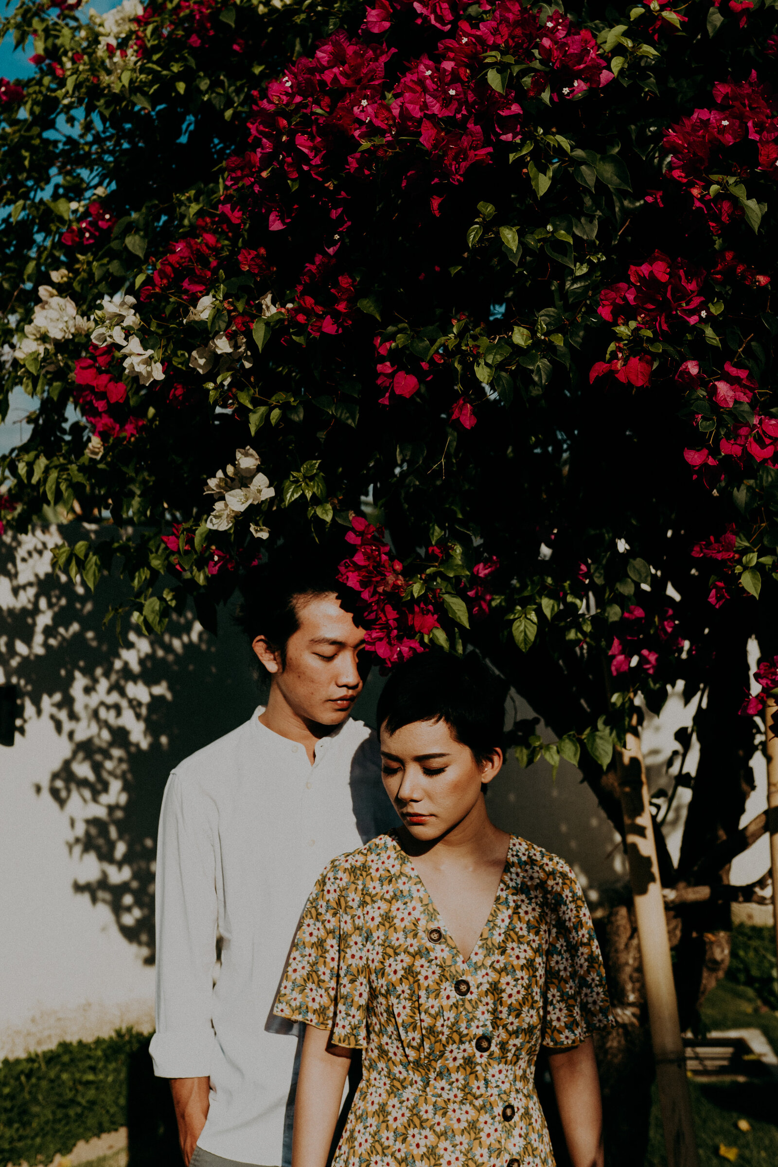 couple standing under flower