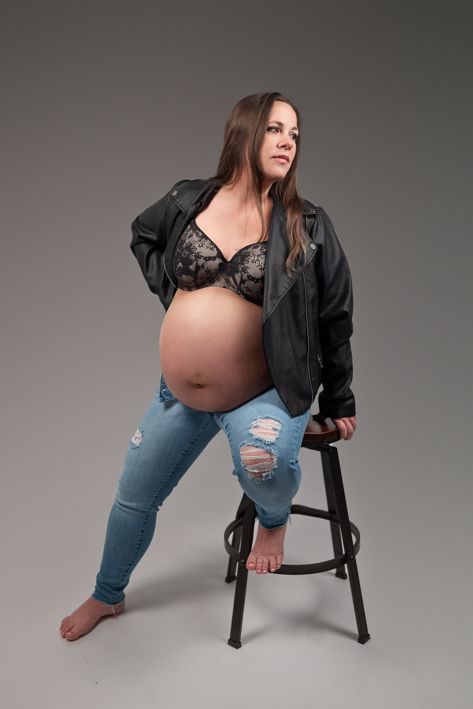 Pregnant woman  posing on a stool for her maternity photos in Huntsville Alabama