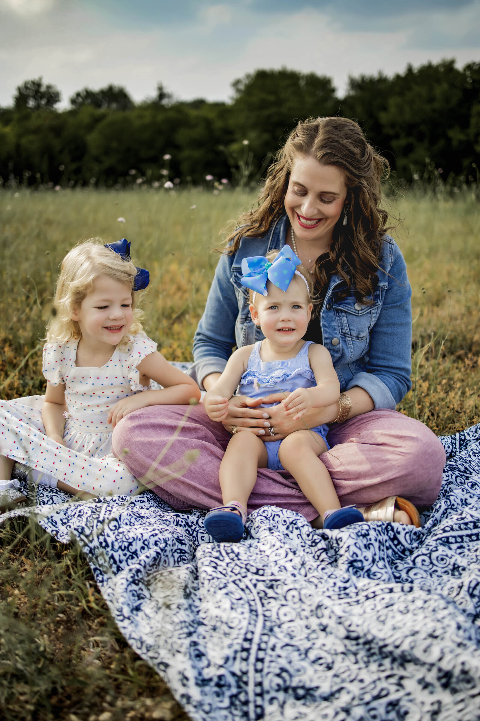 mom and two girls in a field