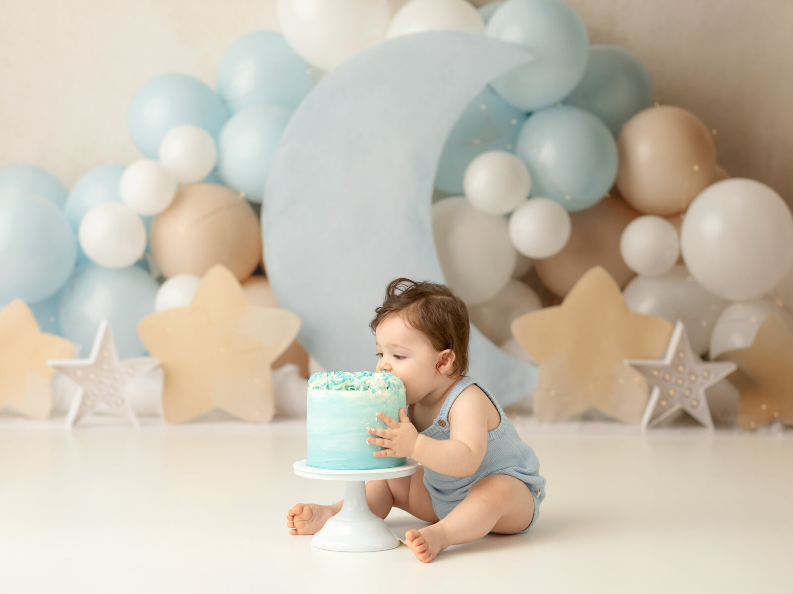 one year old boy eating cake for first birthday cake smash session Cleveland family photographer