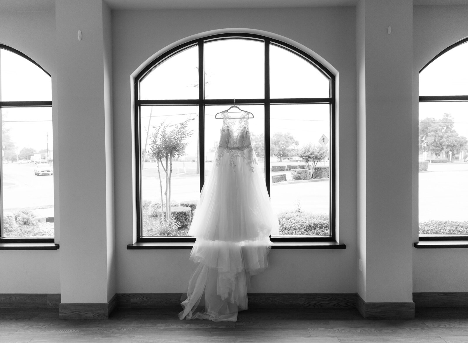 wedding dress hanging in window